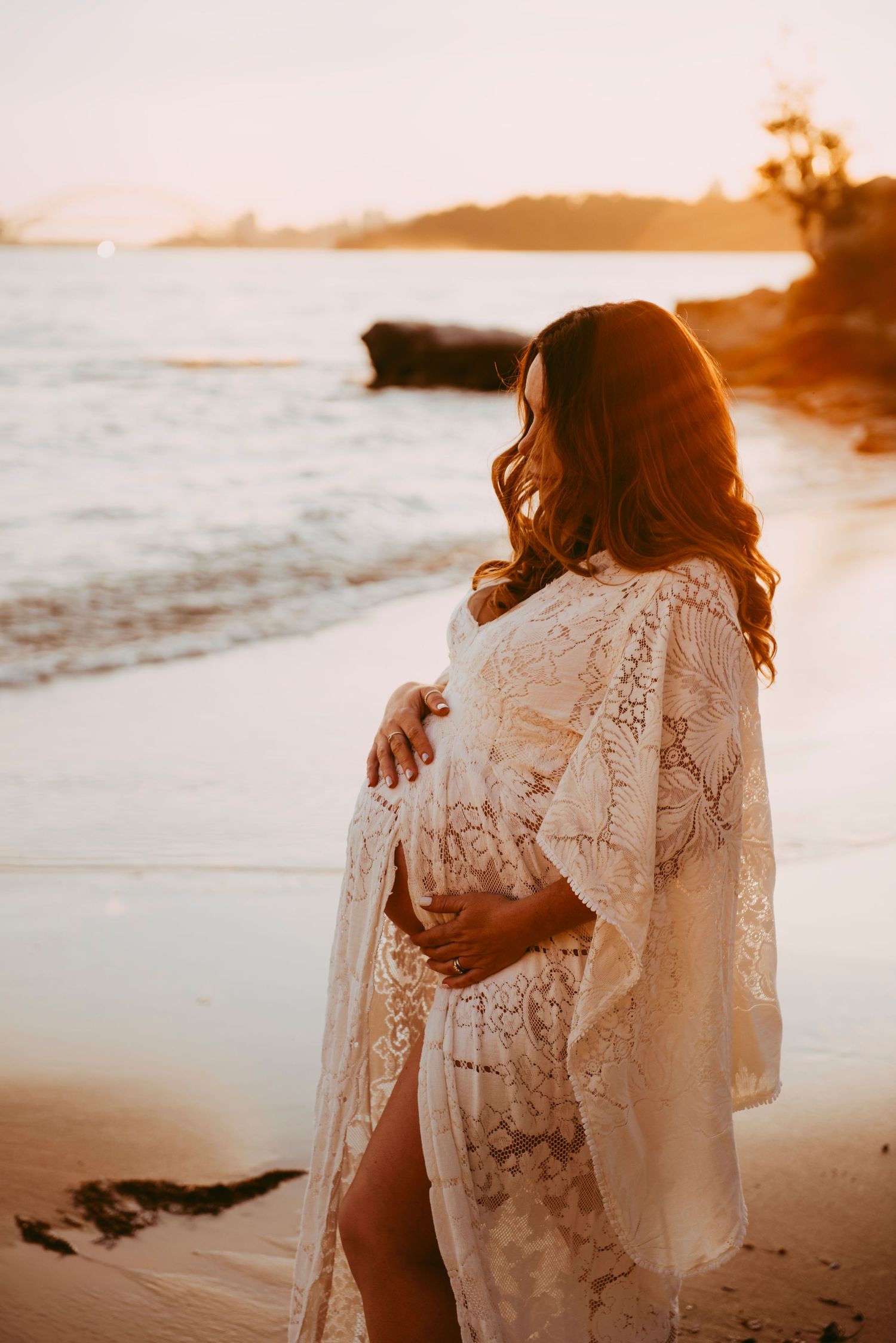 maternity photography Vaucluse Sydney of pregnant mother standing in water at sunset on Sydney Harbour beach, rainbow baby
