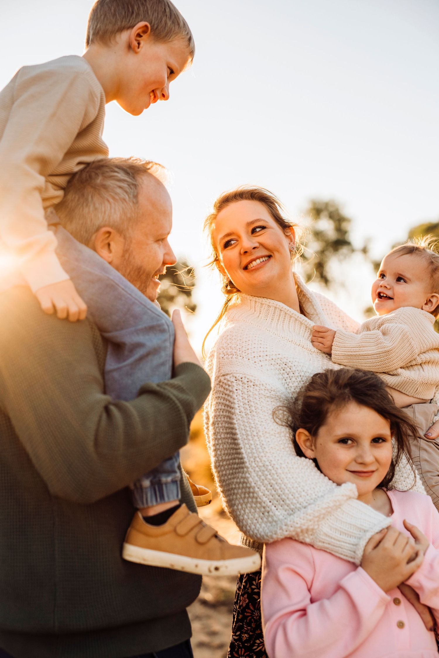 western Sydney photography,  parents holding children at sunset in warm golden light