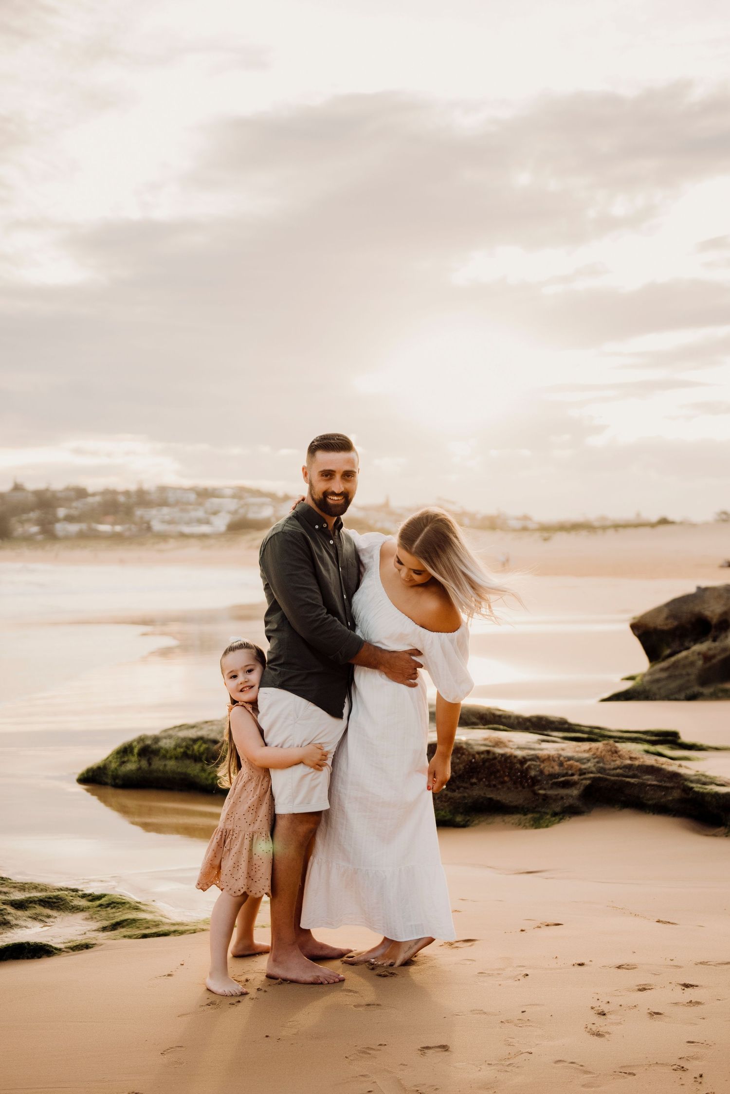 Northern Beaches family photography of father holding child while mother stands nearby