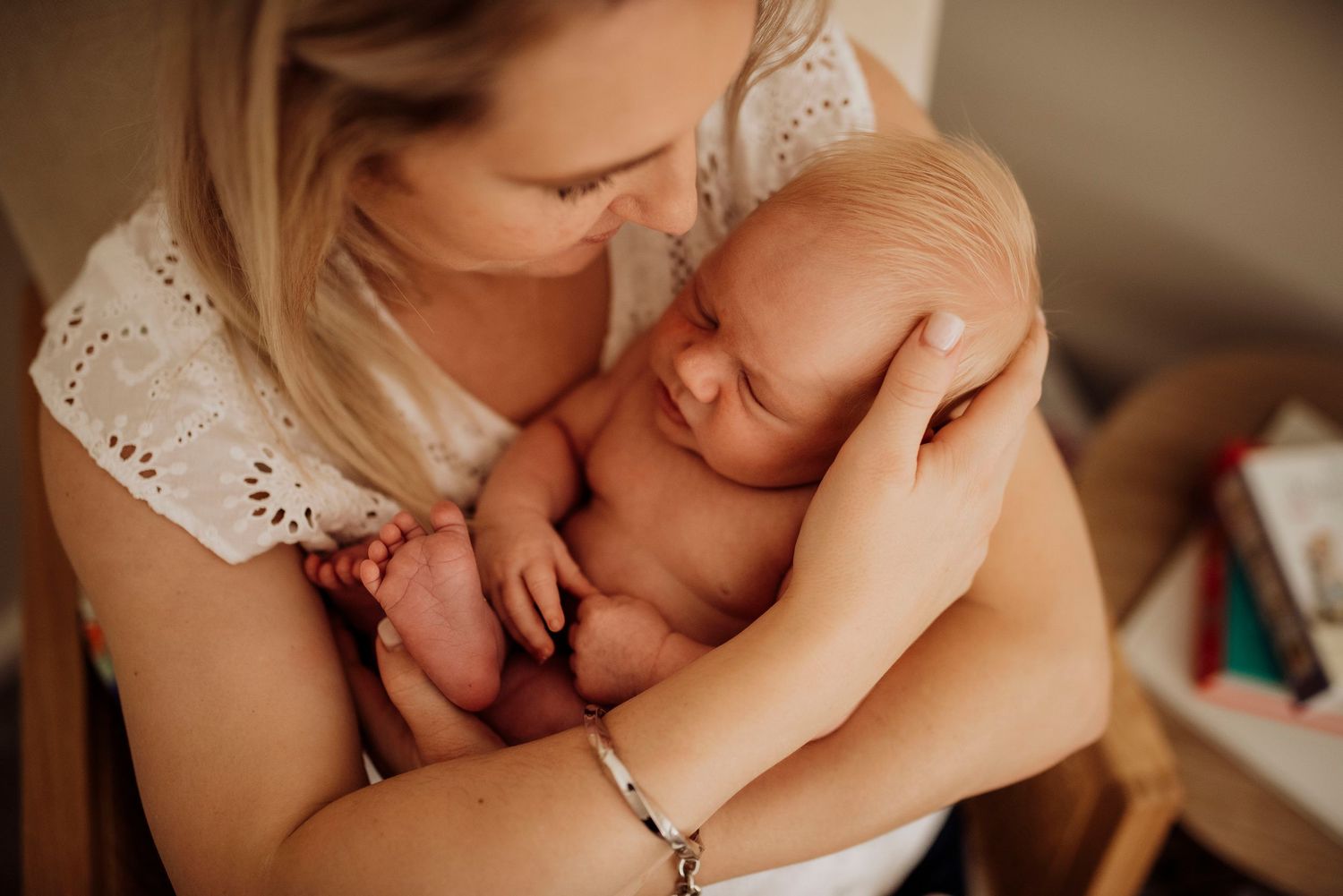 Northern Beaches newborn photography of mother cuddling baby in soft natural light
