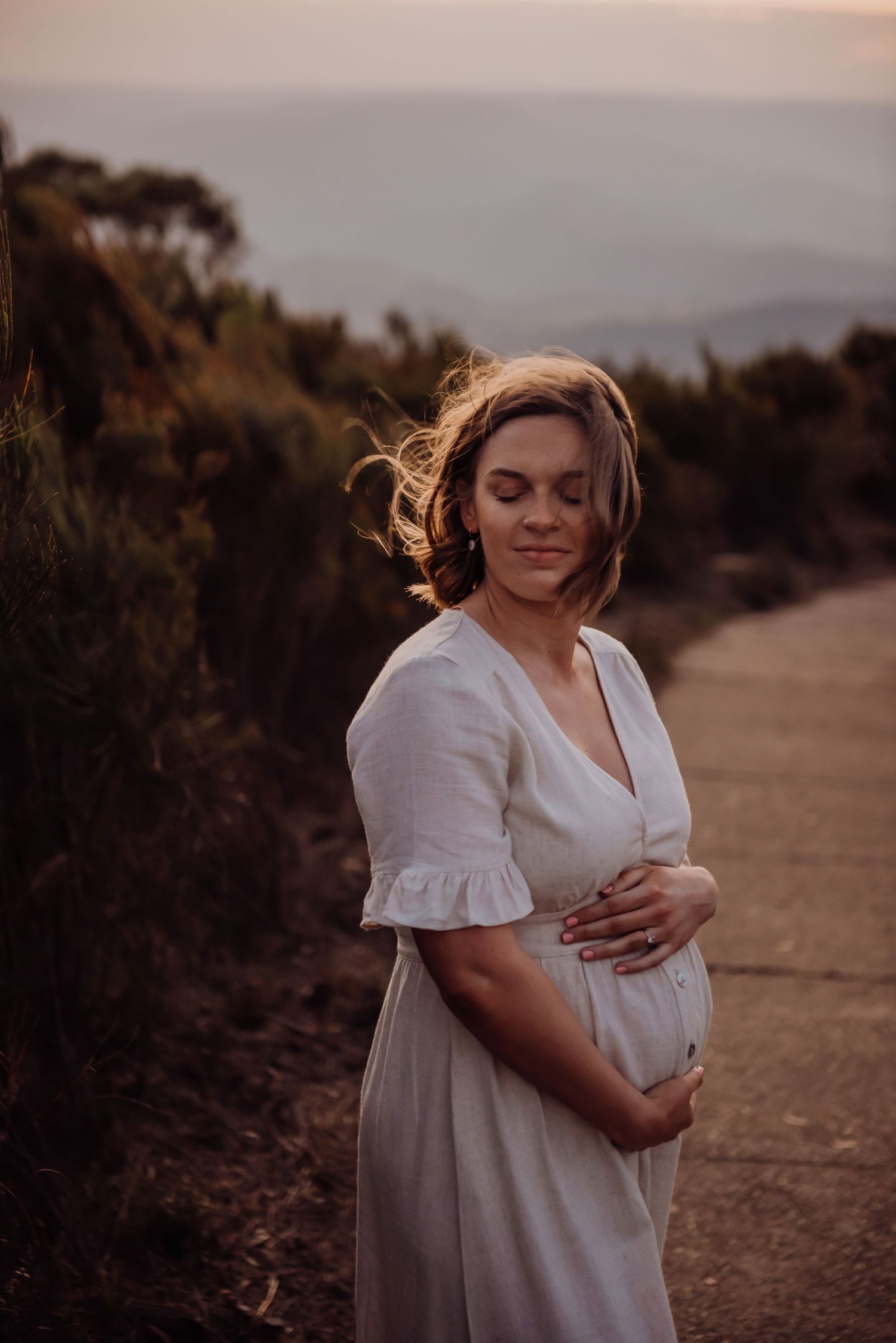 Pregnant woman in soft neutral dress during outdoor maternity photoshoot in Blue Mountains Sydney