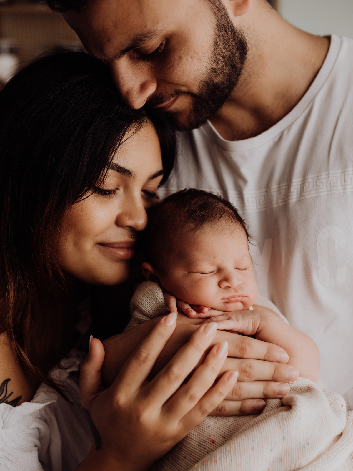 in-home newborn photography Sydney of parents cuddling newborn baby, intimate family connection