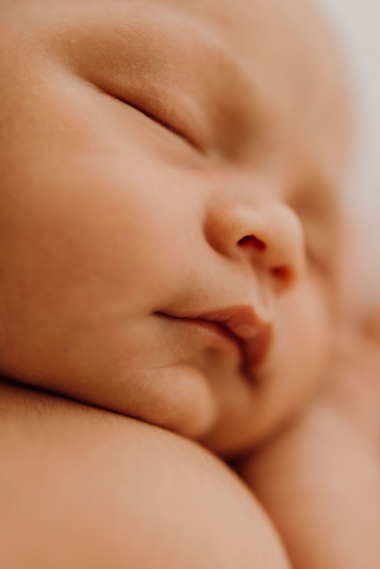 western Sydney newborn photography of baby being gently held during in-home photoshoot