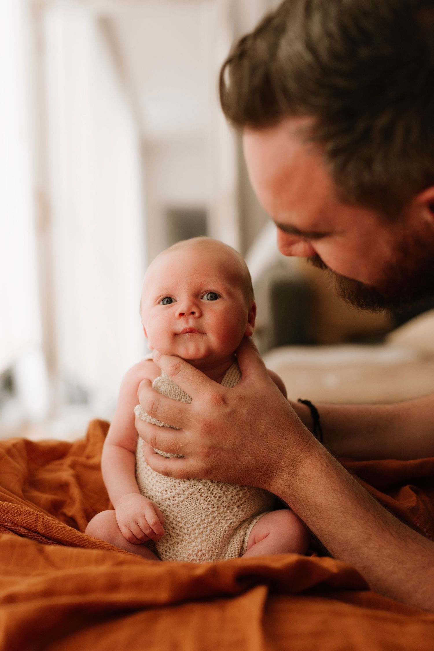 Turramurra newborn photography of father holding baby in warm lifestyle photoshoot