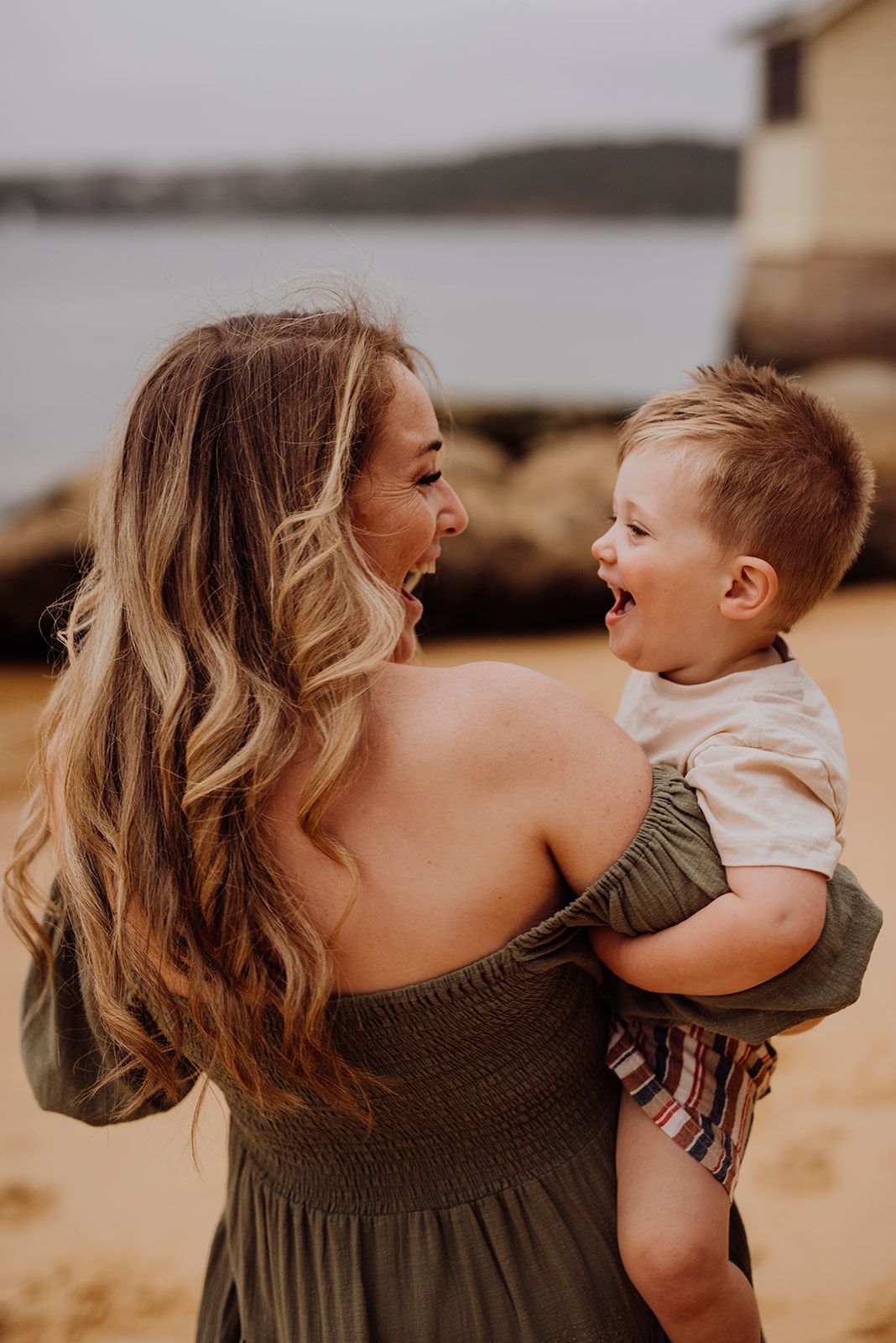 Watsons Bay family photography of mother holding child and laughing on the beach
