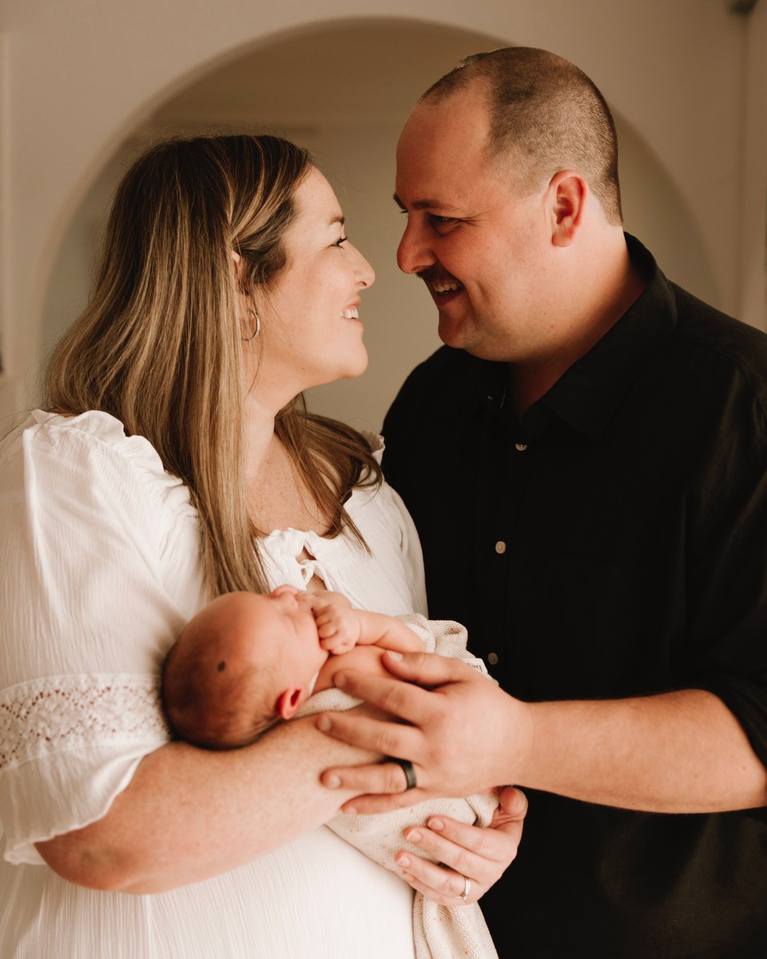 in-home newborn photography Sydney of parents holding their rainbow baby after IVF