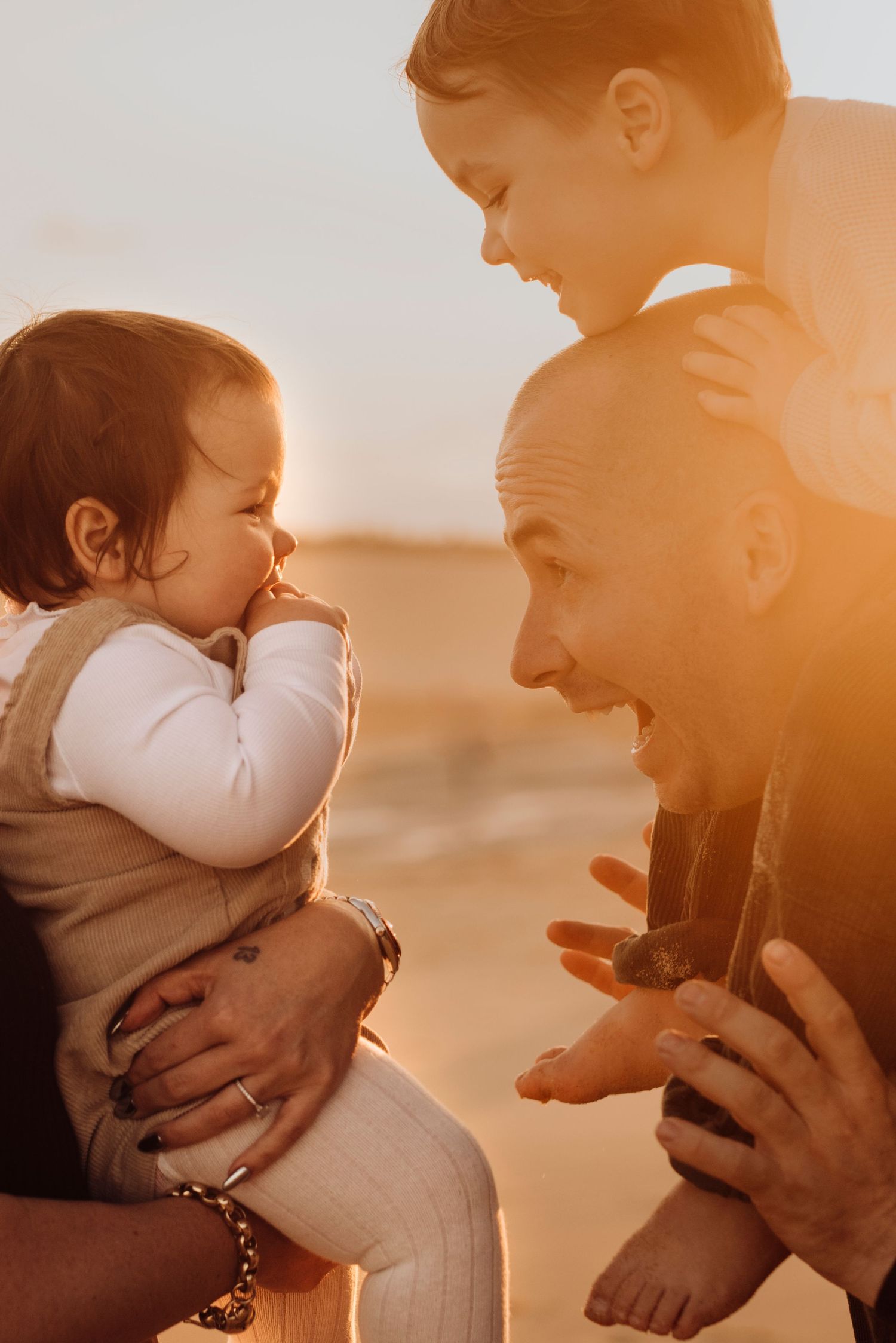 Northern Beaches family photography of father playing with baby in warm golden light