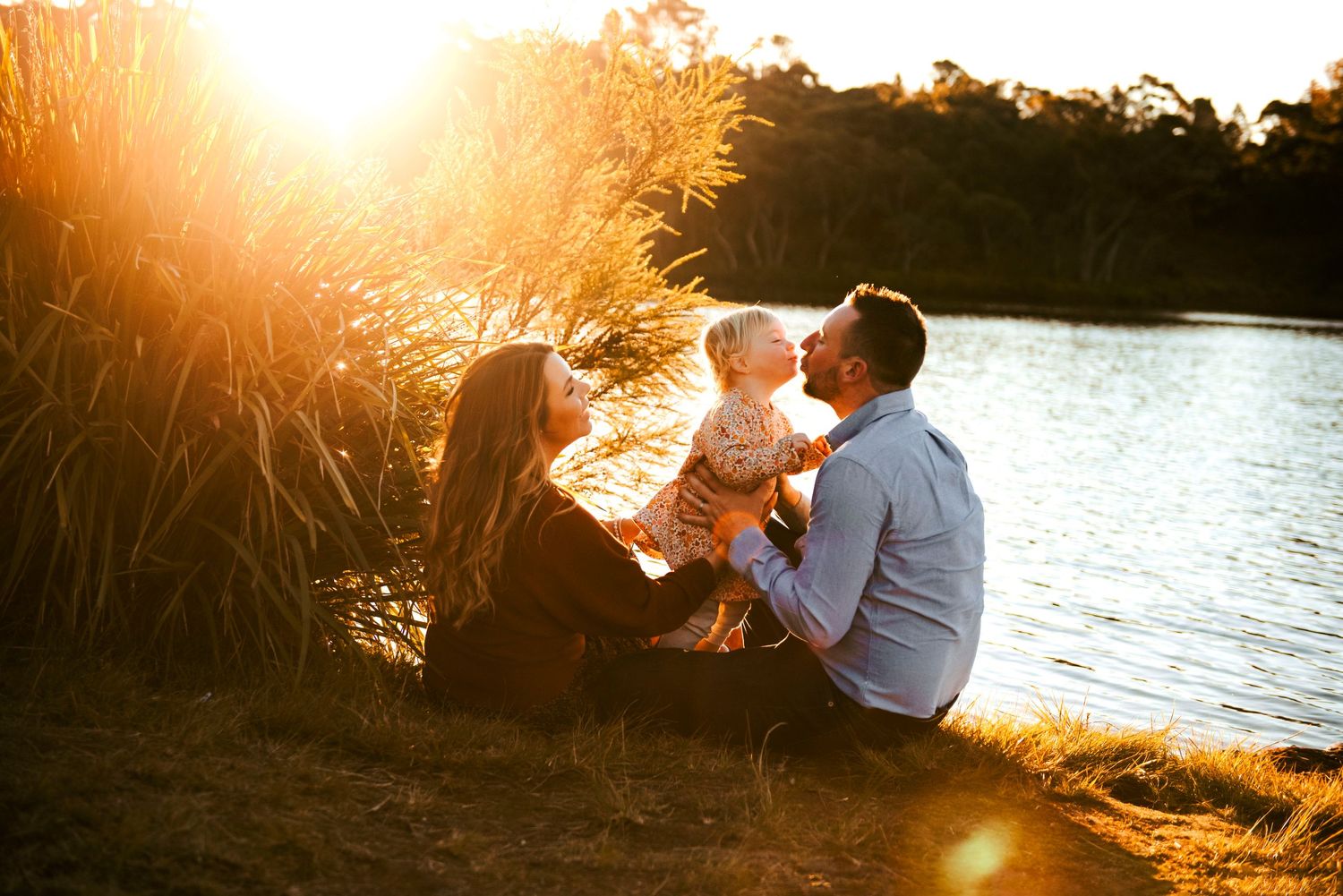 Blue Mountains family photography of family sitting together by wentworth falls lake in warm sunset light