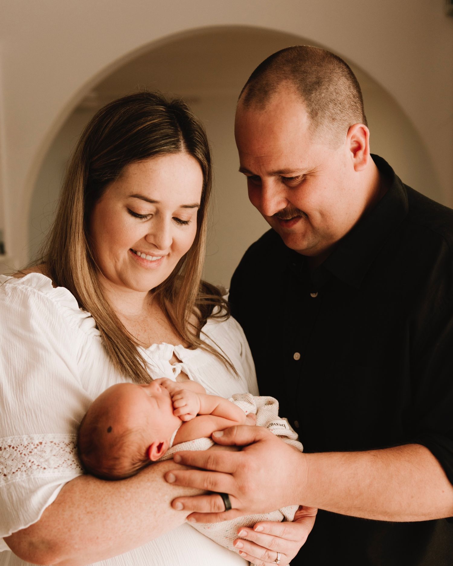 in-home newborn photography Sydney of parents holding their newborn after IVF journey