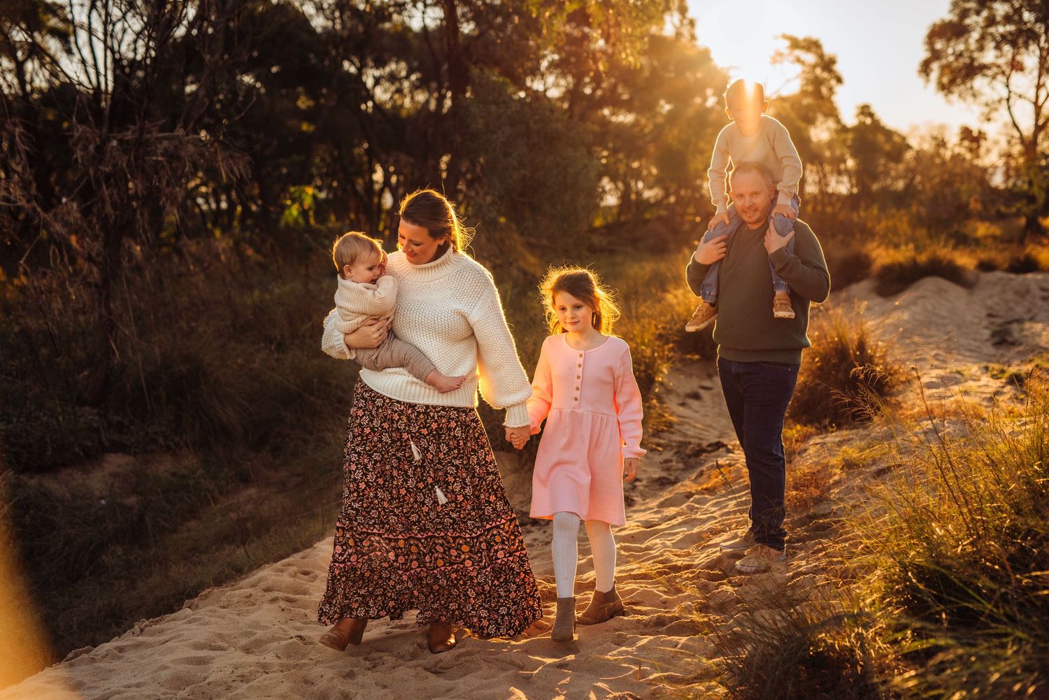 family photography Western Sydney of parents walking with children through bushland at sunset, natural outdoor setting
