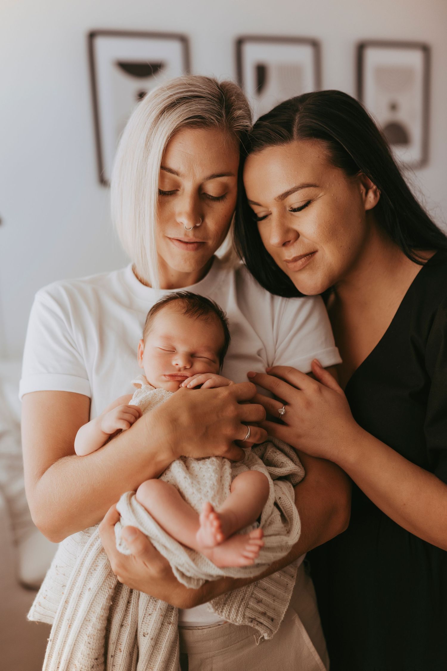 in-home newborn photography Sydney of two mothers holding their newborn baby, reciprocal IVF success story