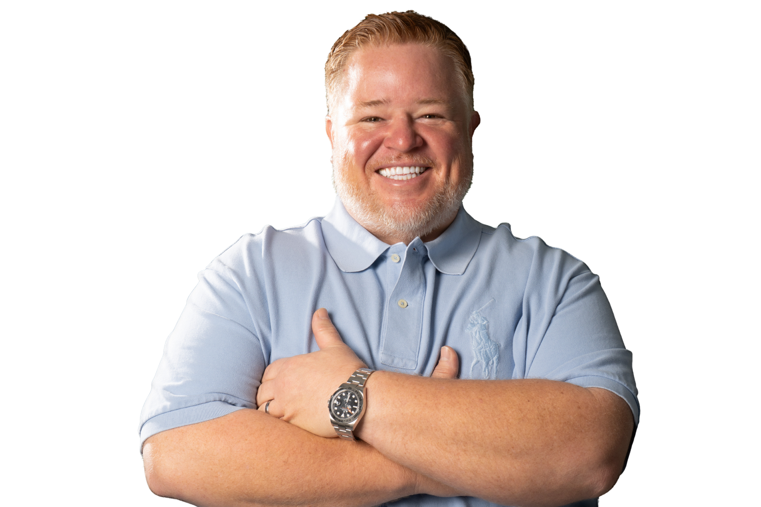 Smiling man with crossed arms wearing a light blue polo shirt and watch on white background.