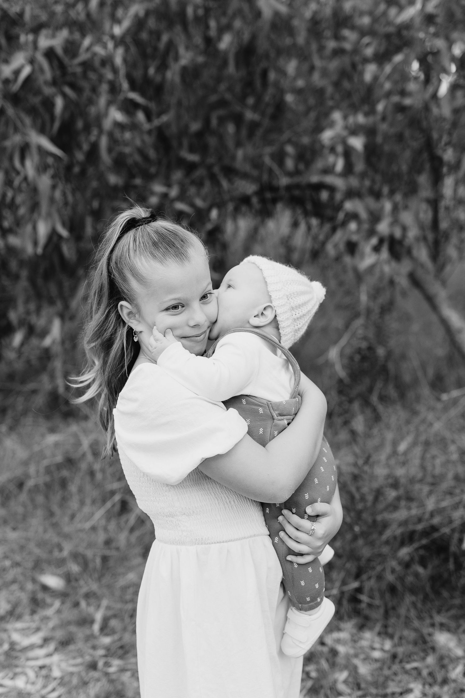 A tender black and white moment captured between two people sharing happiness outdoors.