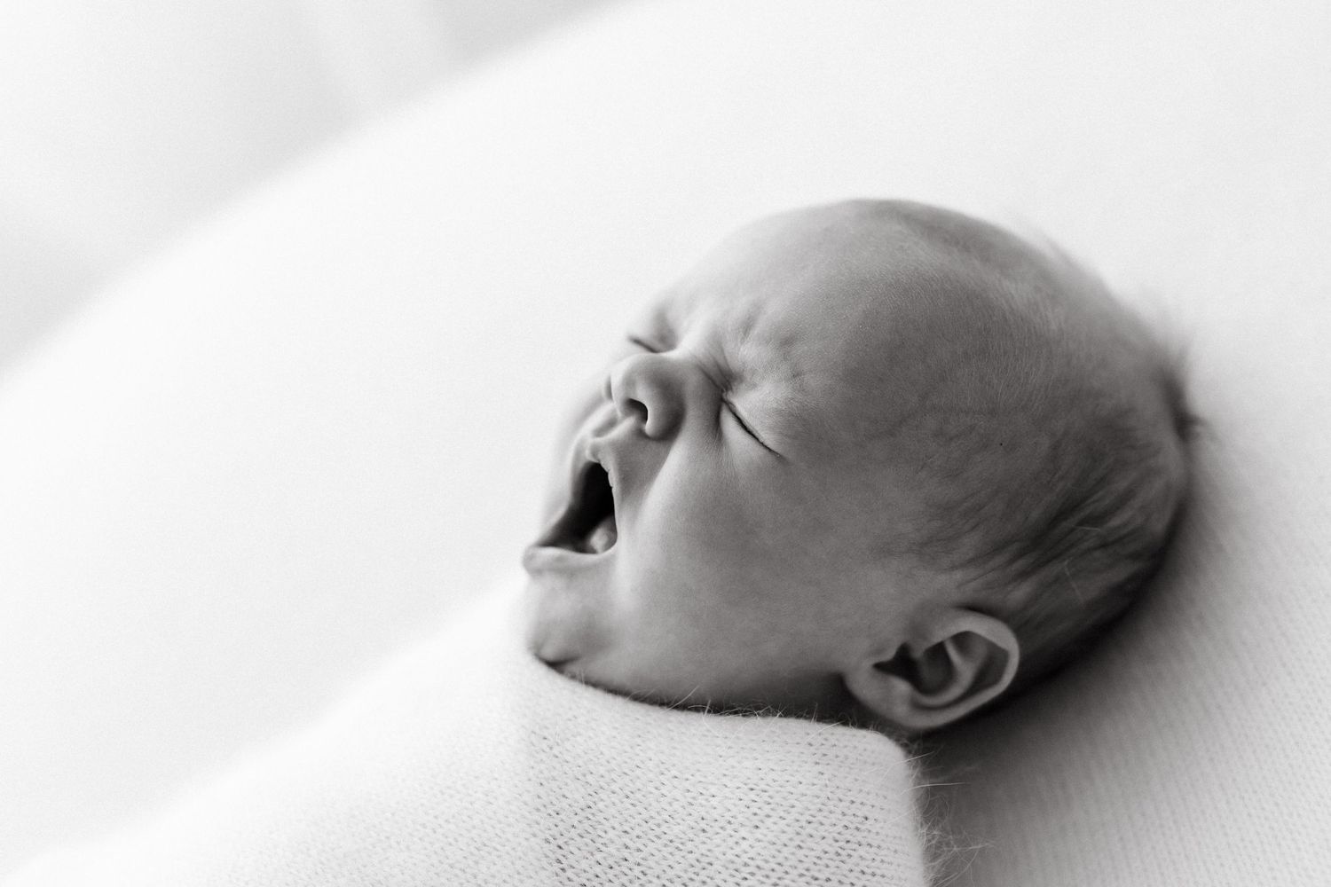 Close-up black and white profile of a sleeping newborn baby.