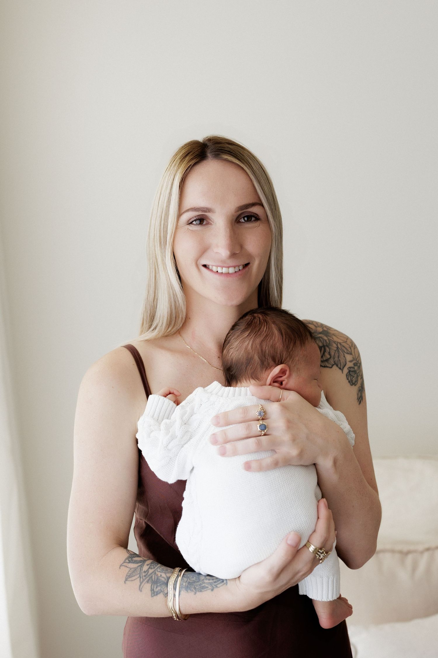 Series of tender moments between parent and newborn in white clothing.