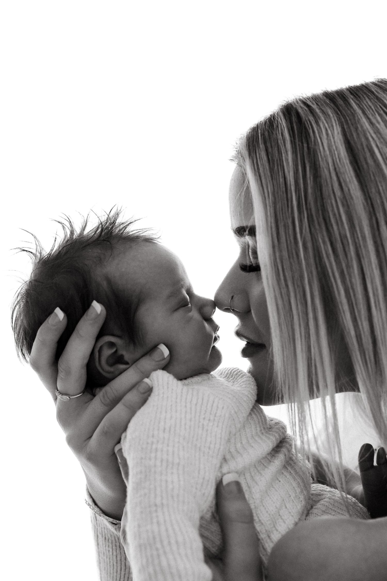 Intimate black and white portrait of tender moment between parent and baby.