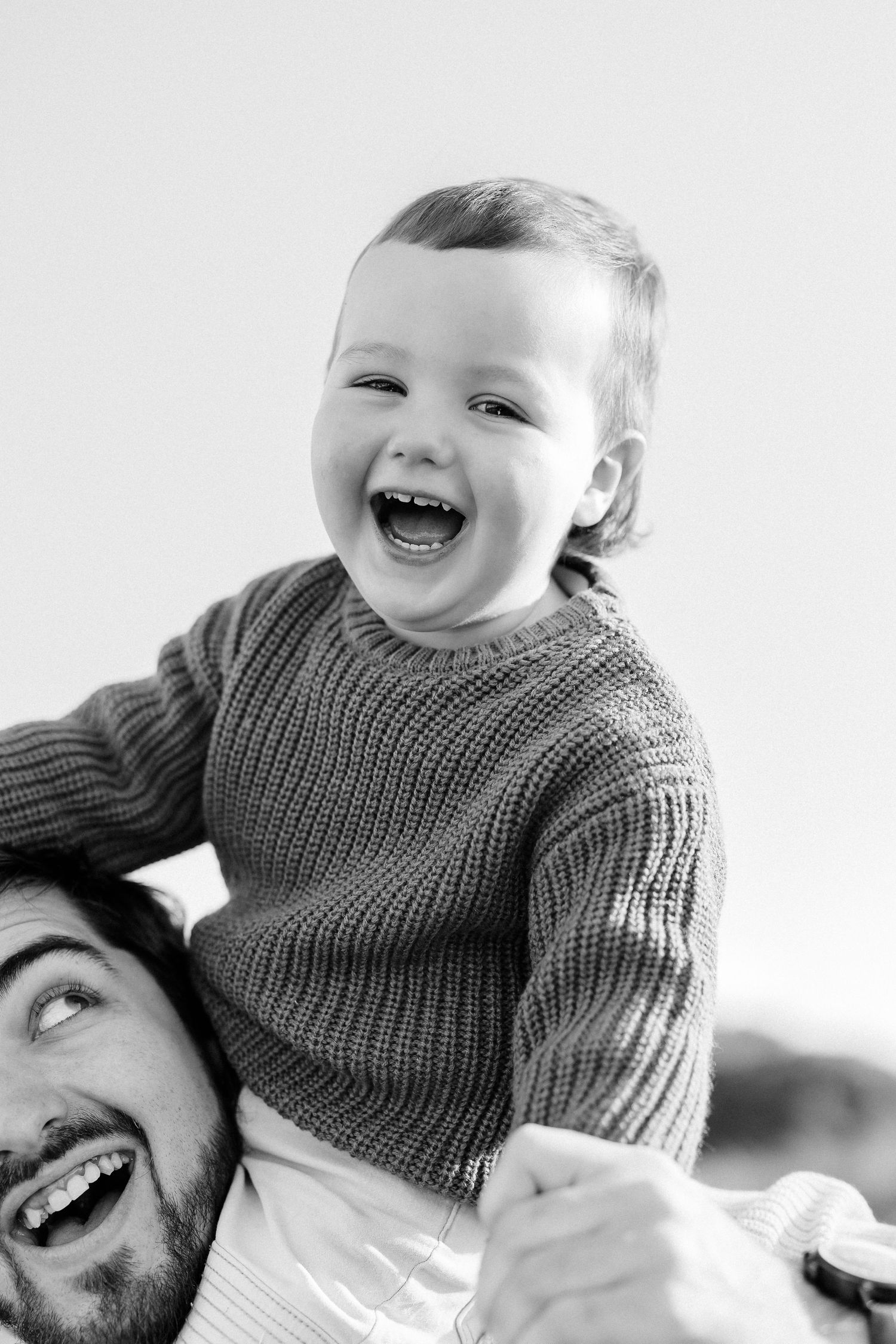 Joyful black and white portrait of playtime with a knit sweater.