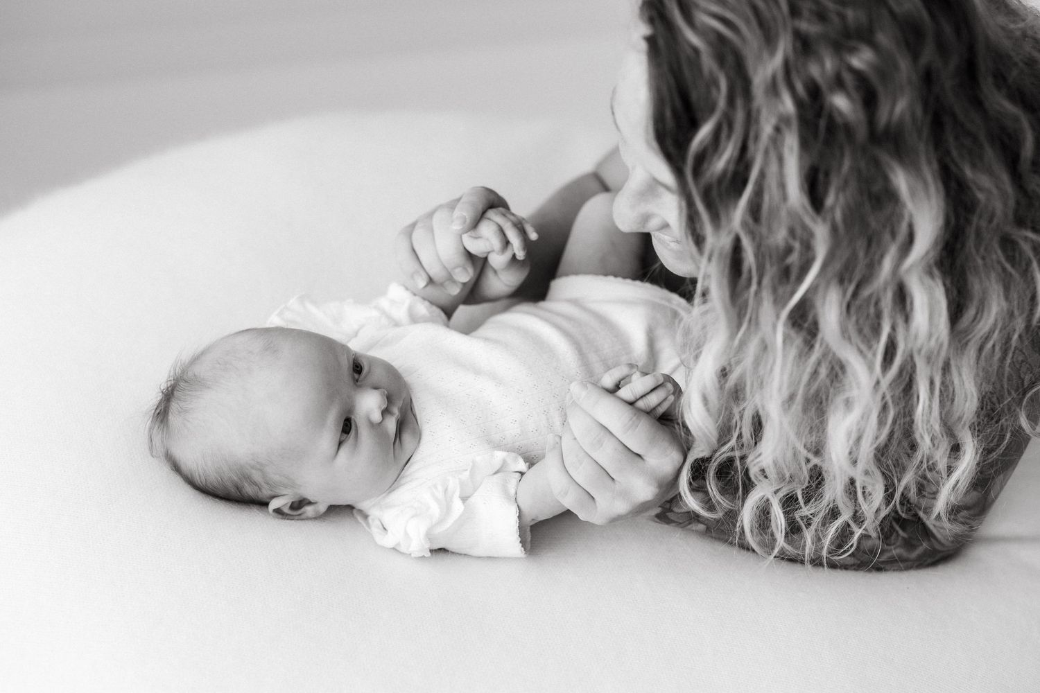 Black and white image of a tender moment between caregiver and infant.