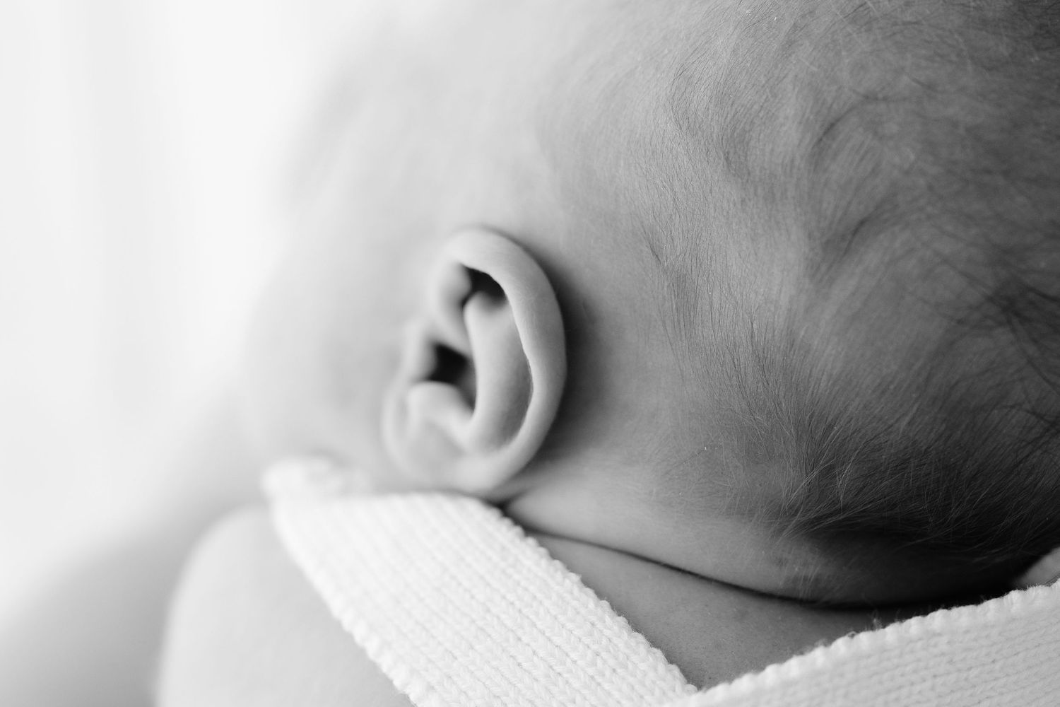 Close-up black and white photos focusing on a baby's delicate features.