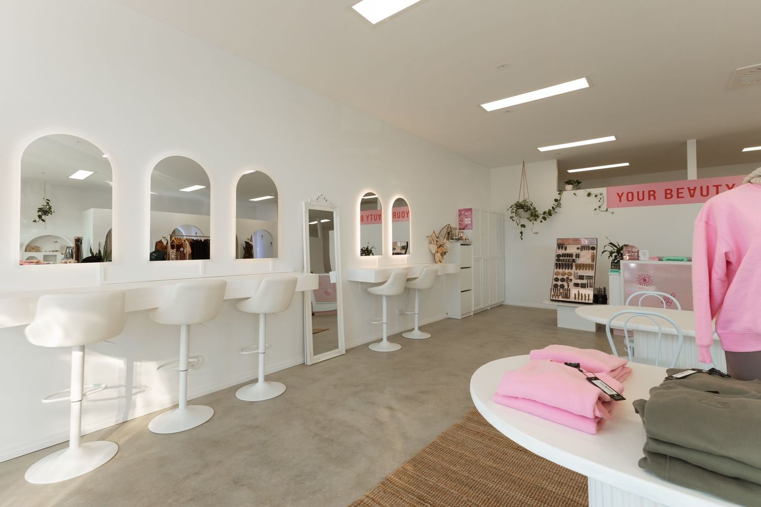 Modern white interior hallway with minimalist design features pink accents and curved architectural elements.