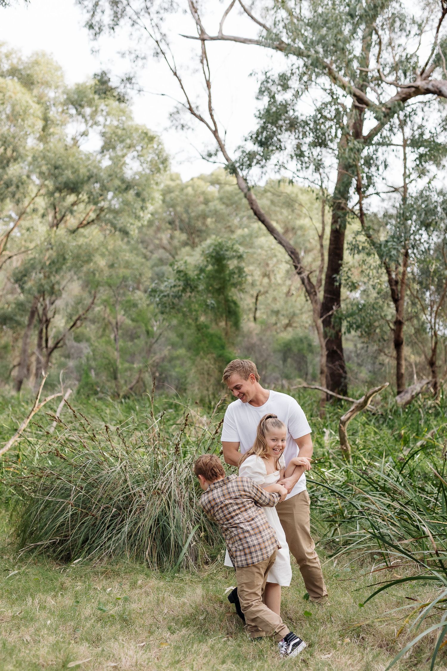 Playful outdoor moment captured among eucalyptus trees in natural setting.