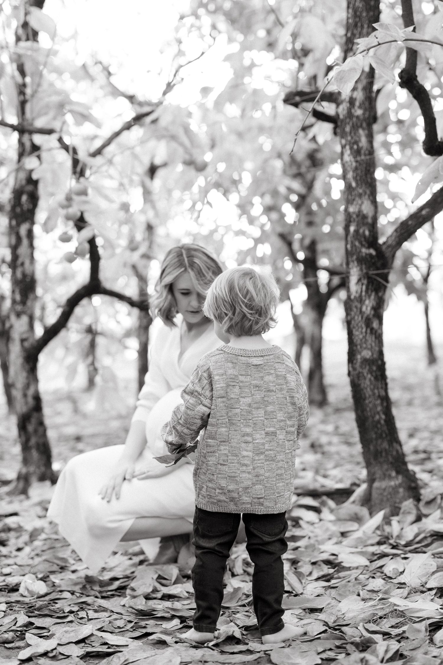 Black and white photo of a peaceful moment between two people in a wooded setting.
