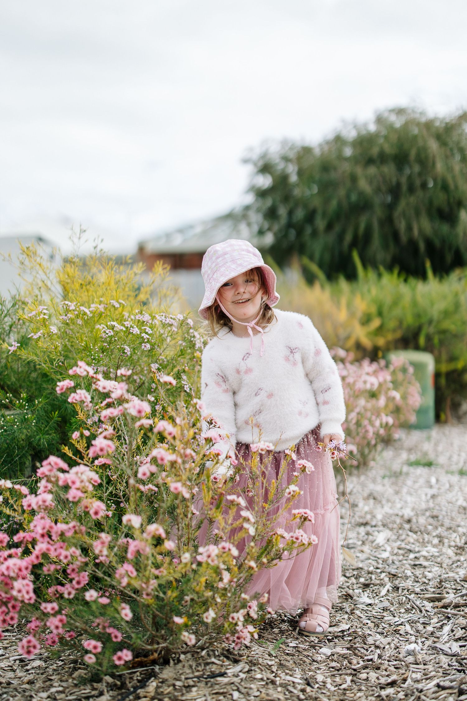 Dreamy garden scene with pink wildflowers and a matching pink tulle skirt outfit.