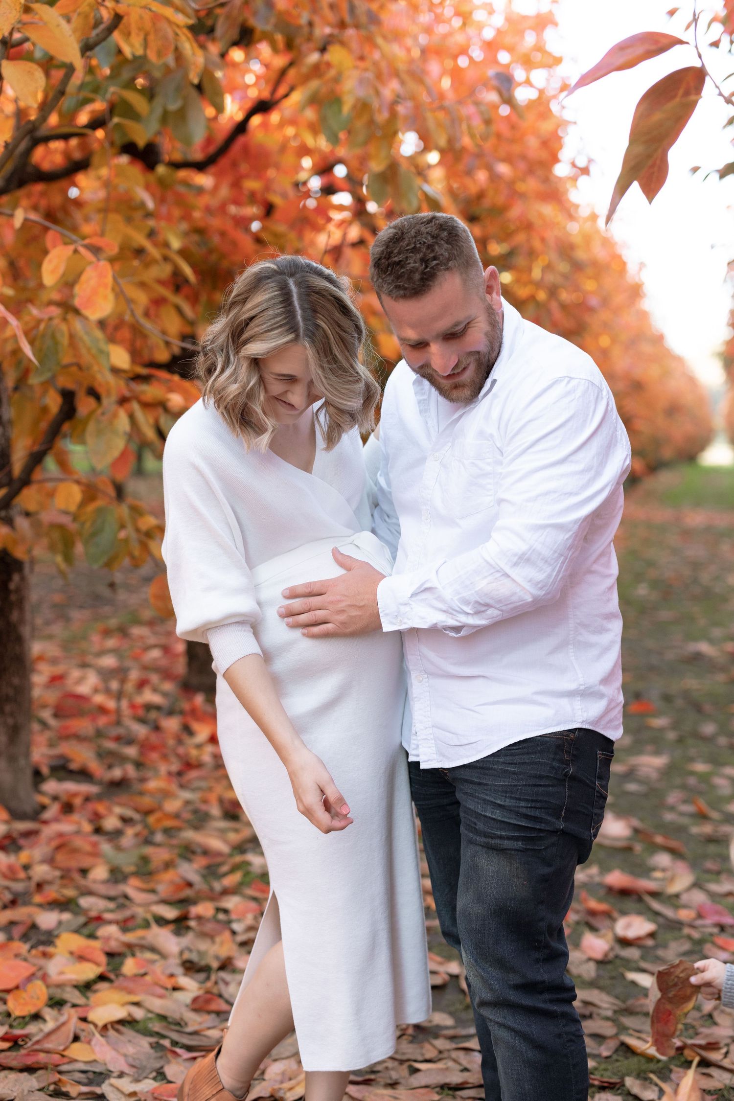 Couple sharing a tender moment under vibrant fall foliage.
