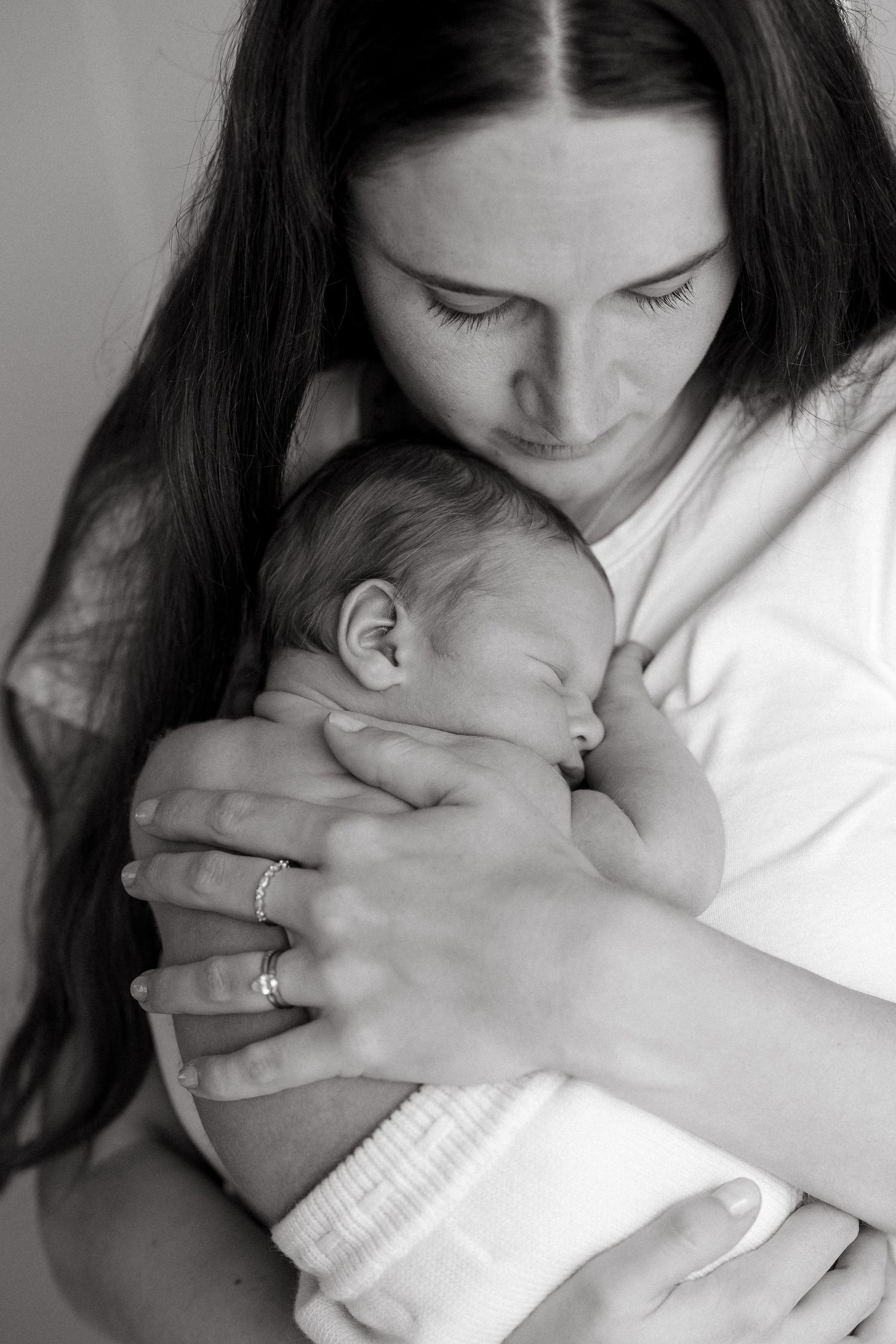 Black and white image of tender moment between mother and newborn.