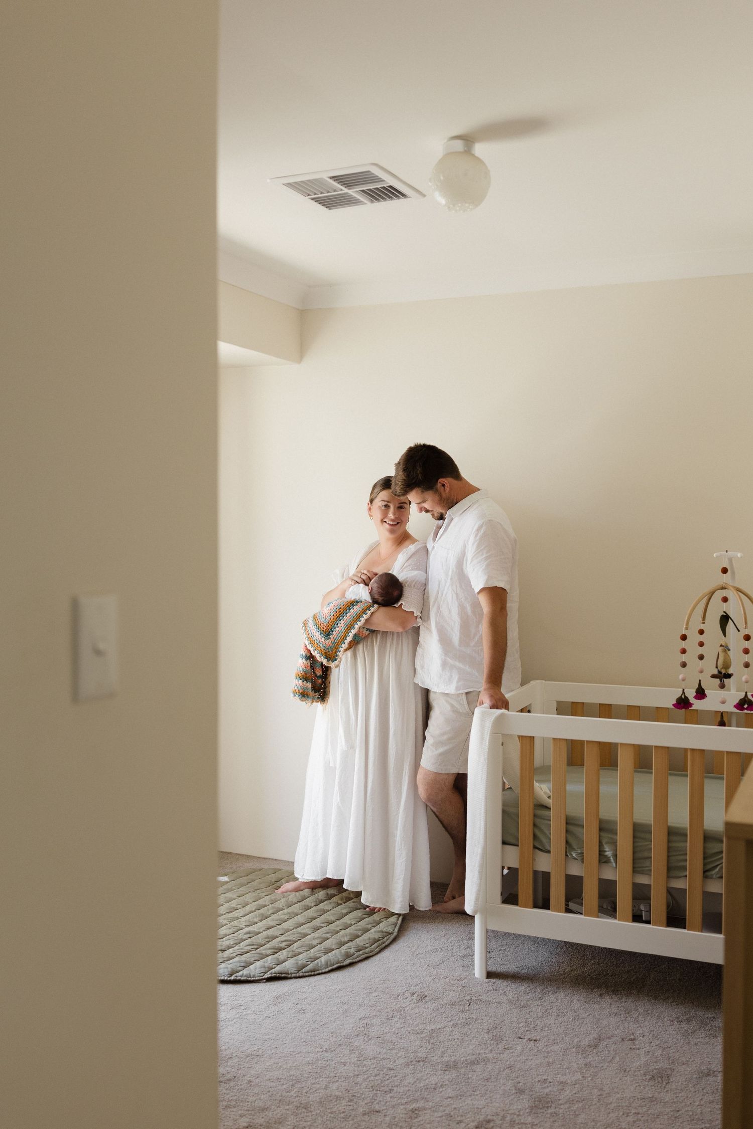 Nursery room interior with white crib and gentle lighting.