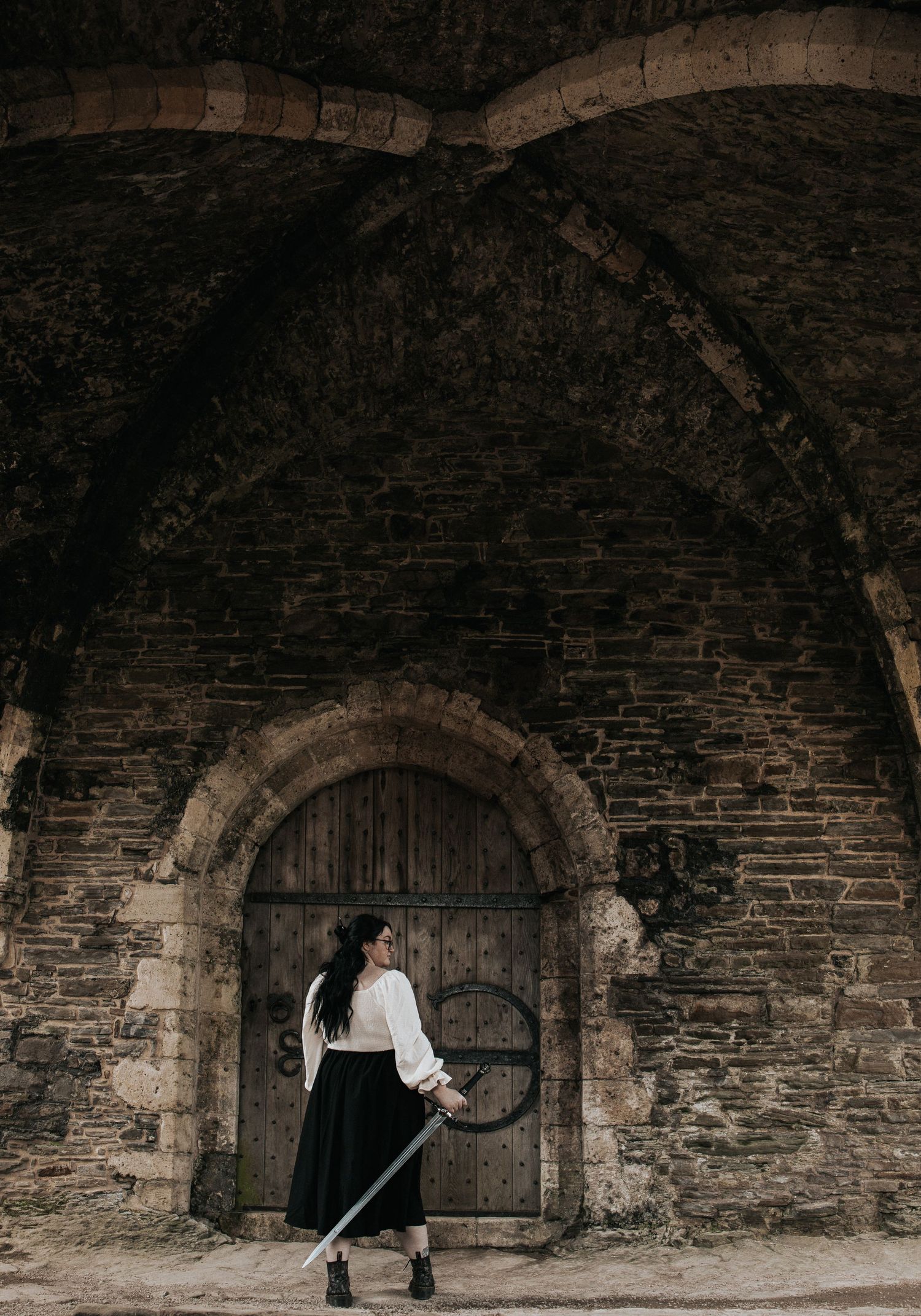 Atmospheric shot of stone archways and wooden doors in an ancient building.