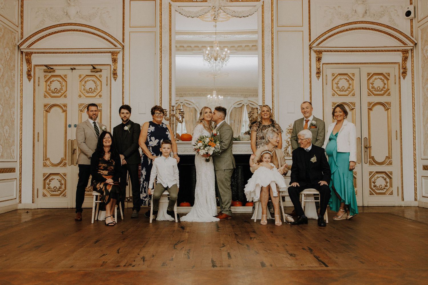 Elegant ballroom wedding venue with ornate gold trim and hardwood floors.