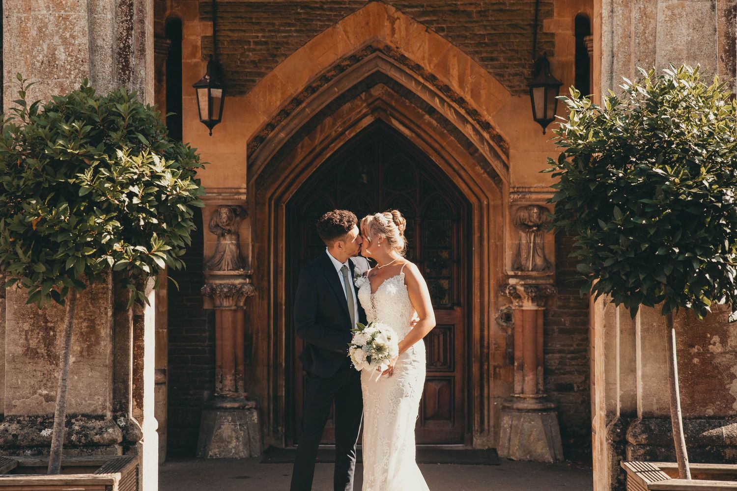 Wedding portraits captured against historic brick architecture with gothic arches.