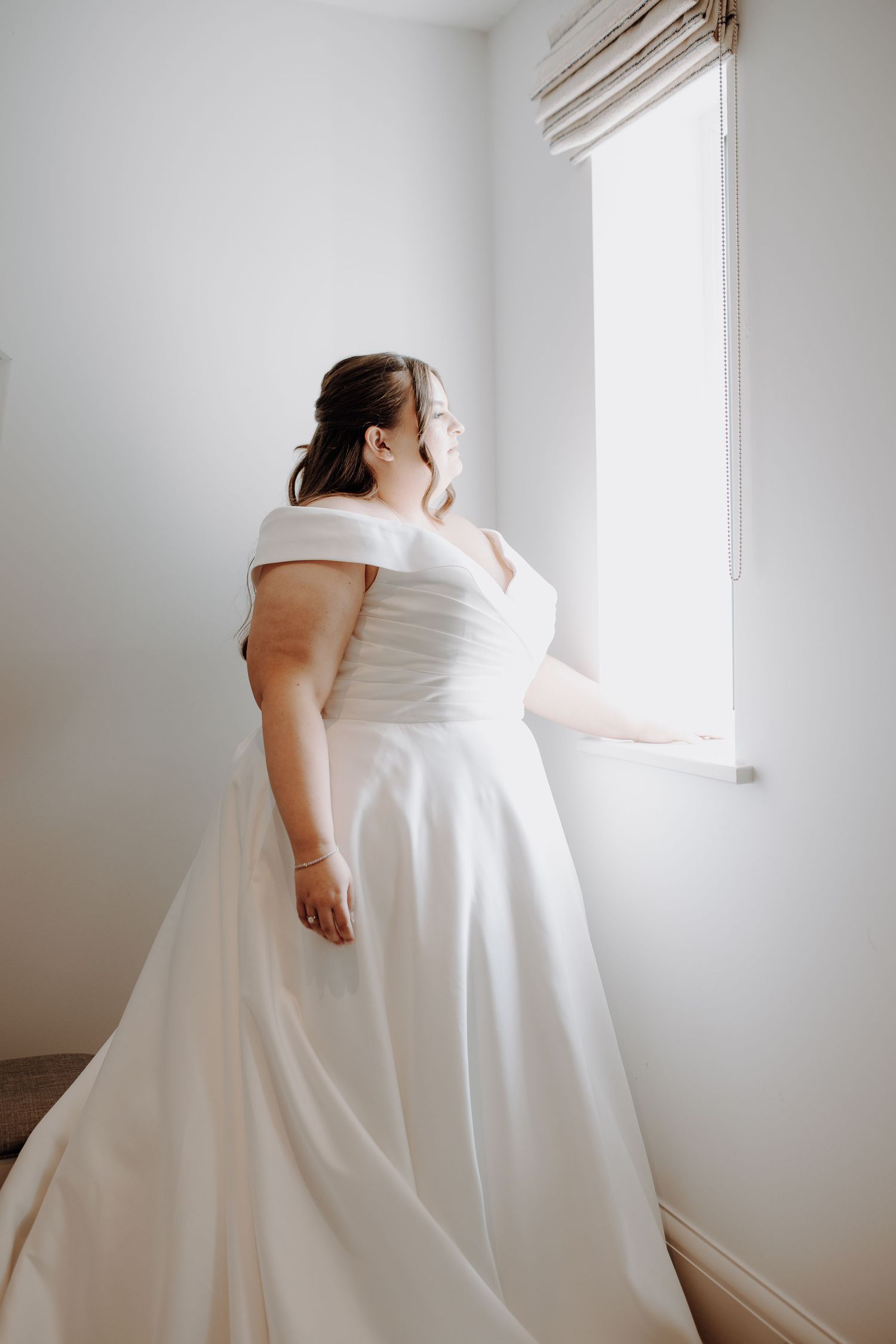 A sequence of artistic photos showing the flowing movement of a white wedding dress against a light wall.