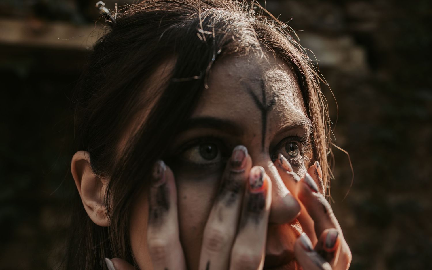 Close-up artistic portrait with dramatic shadows and lighting effects.