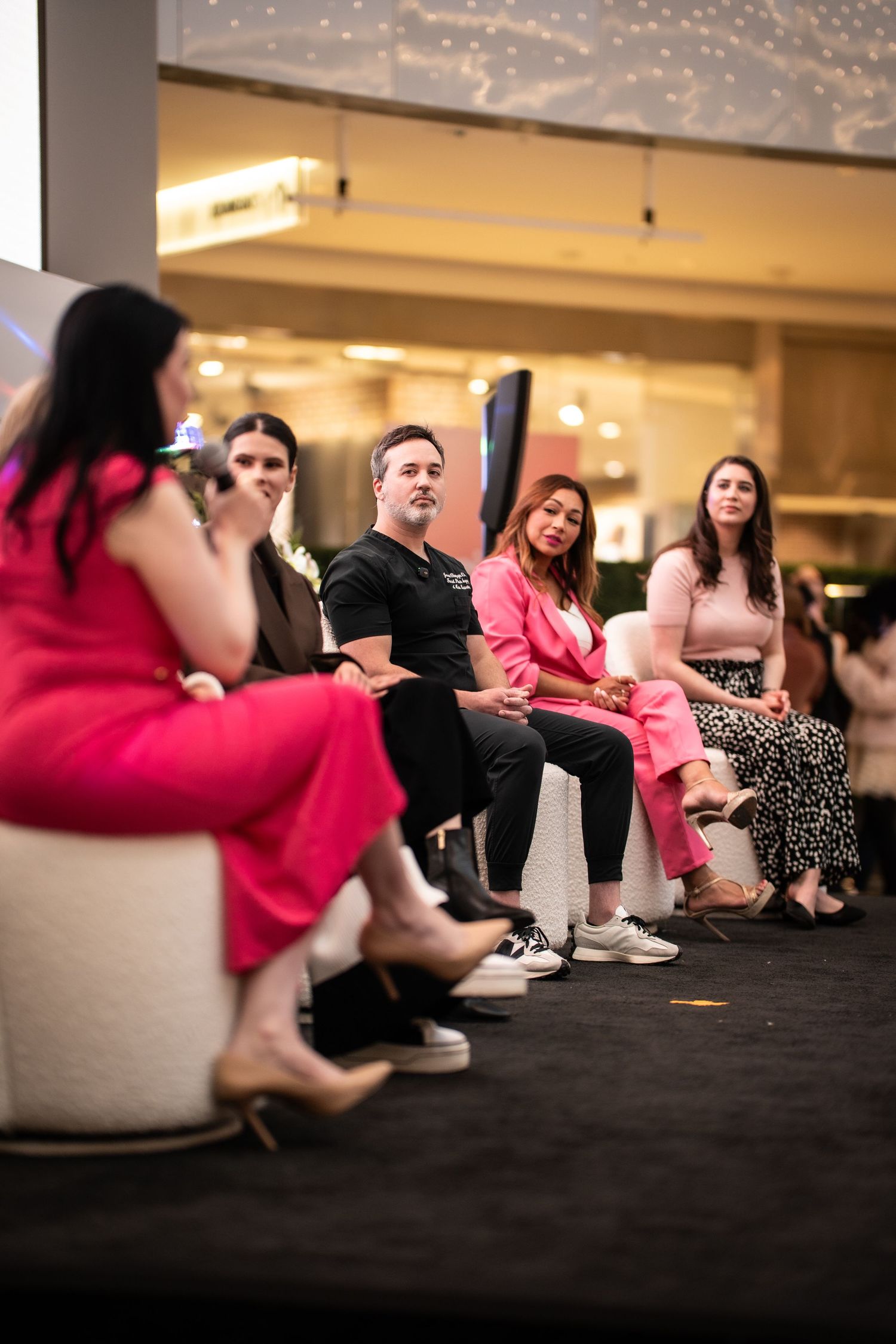 A panel of five people seated on stage at an indoor fashion or lifestyle event.