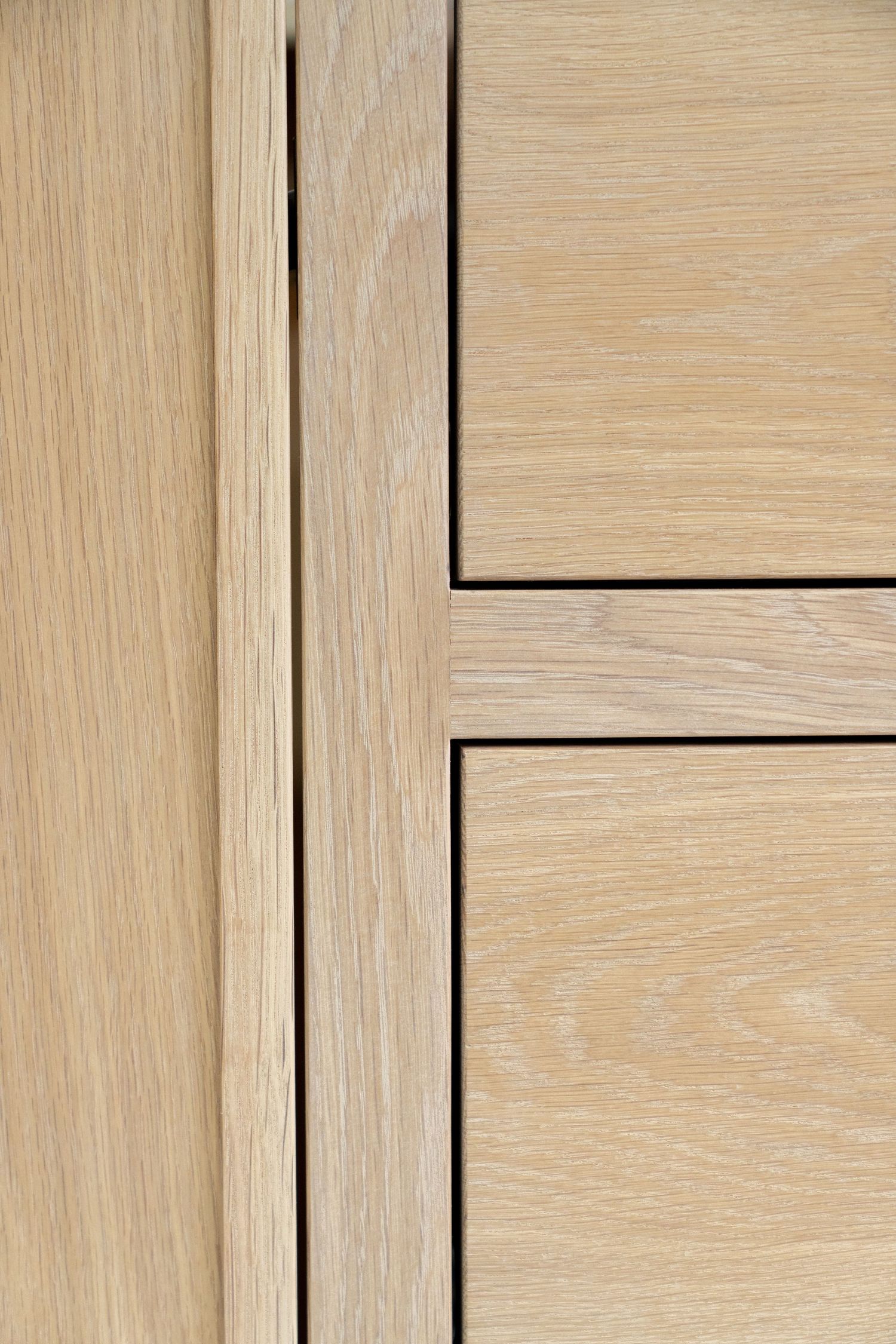 Close-up of light oak wood cabinet panels with clean lines and natural grain texture.