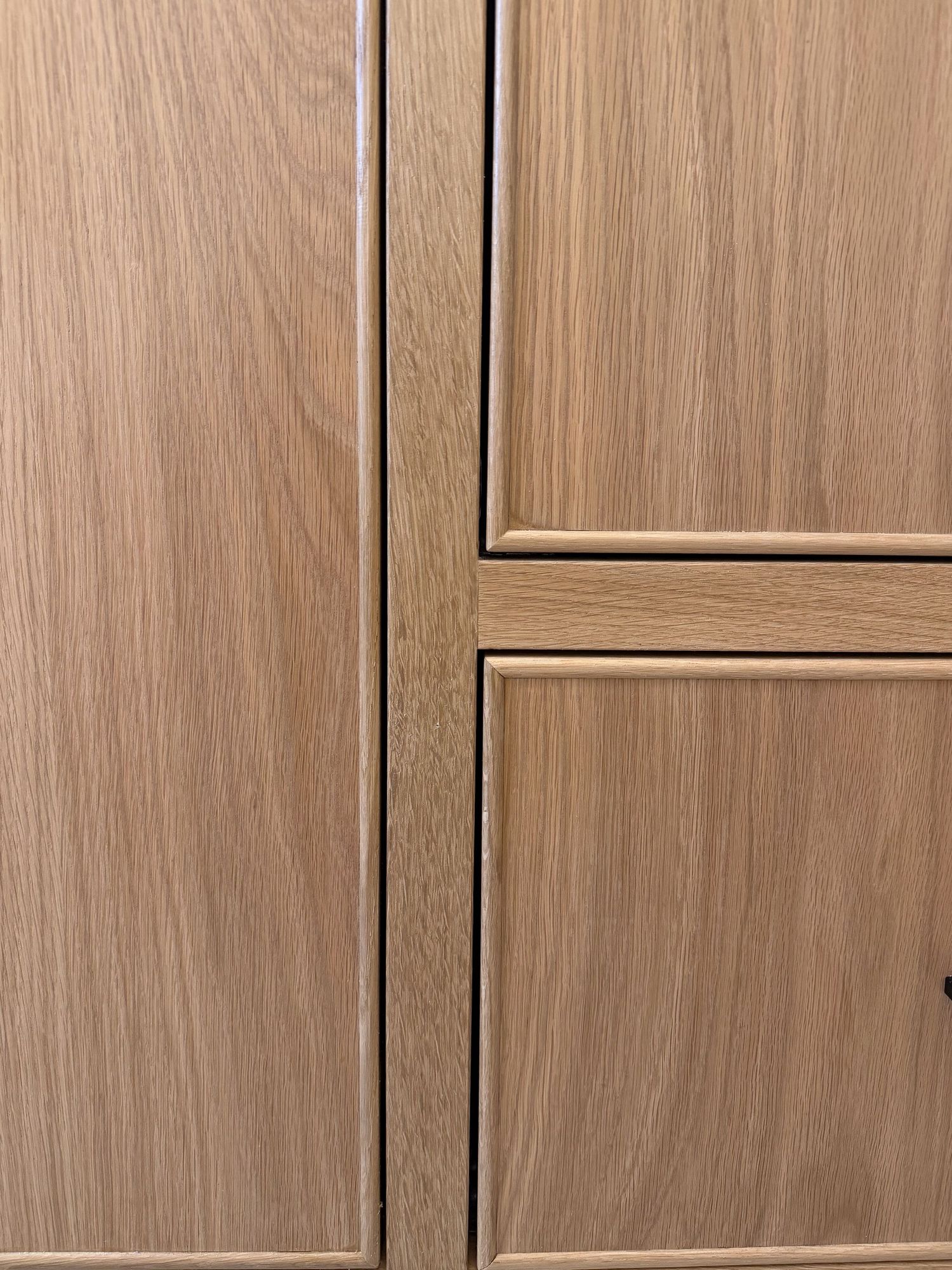 Custom wood cabinet doors featuring geometric panel designs in natural oak finish.