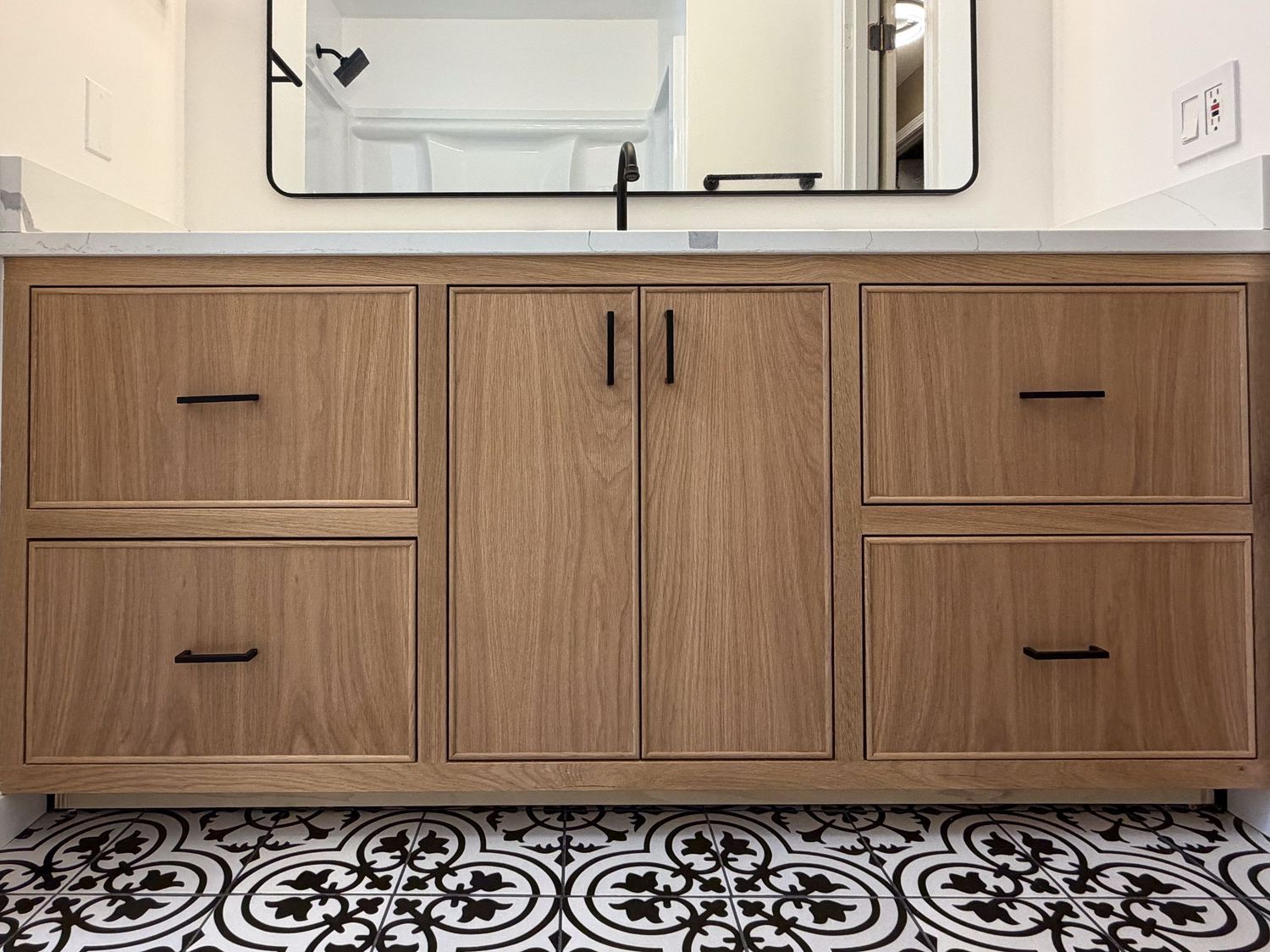 Modern walnut bathroom vanity with black hardware and clean lines.