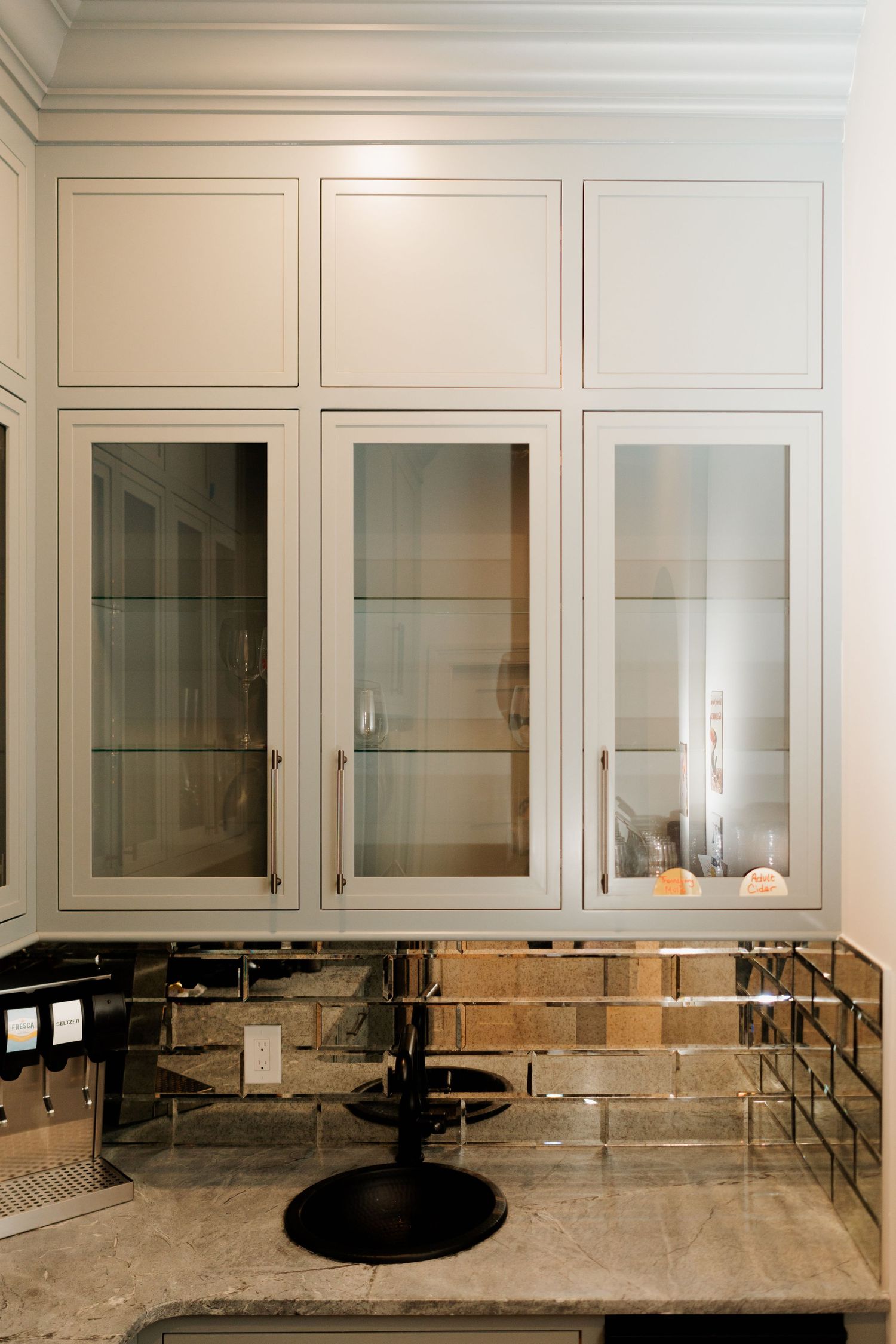 Luxury butler's pantry with glass-front cabinets, marble countertops, and built-in storage.