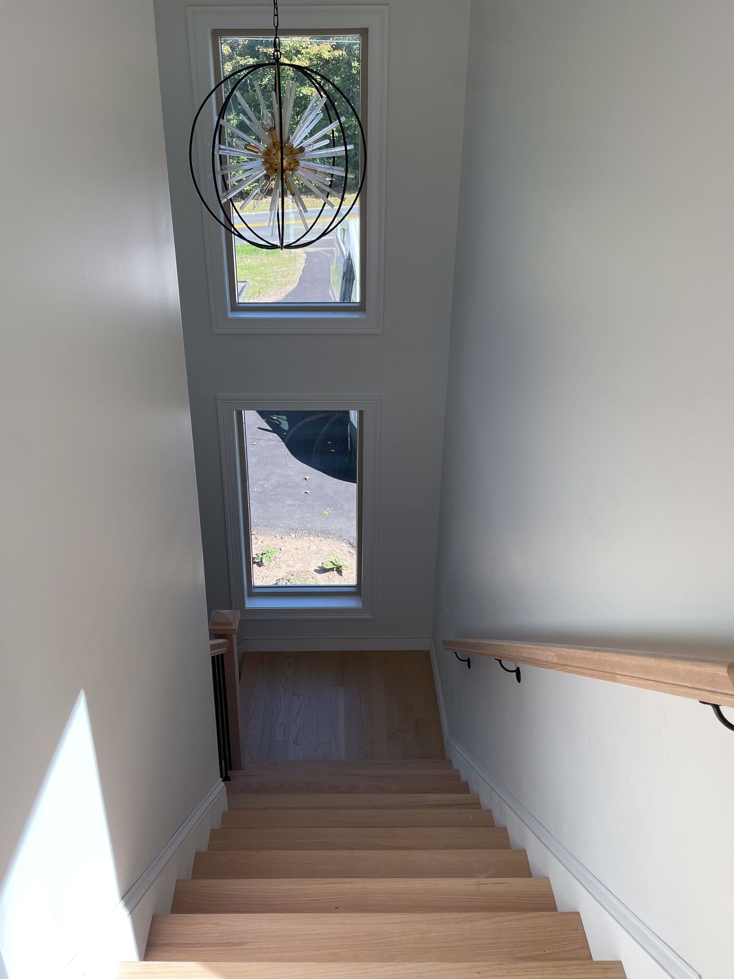 Stairwell landing with decorative round window and natural light streaming in.