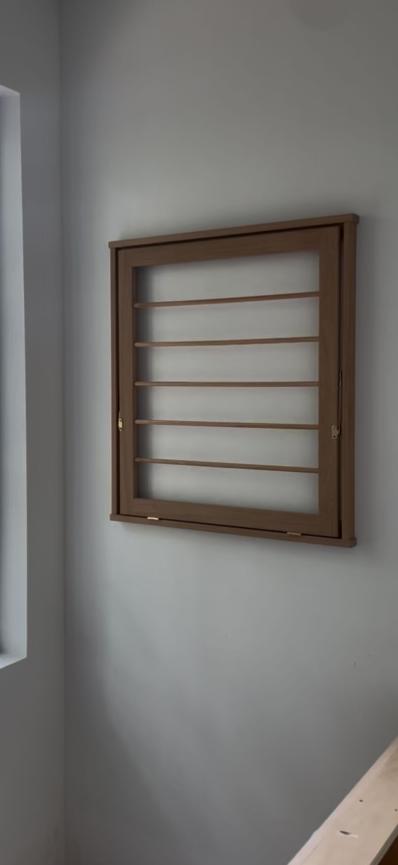 Wooden wall-mounted drying rack in a minimalist design.