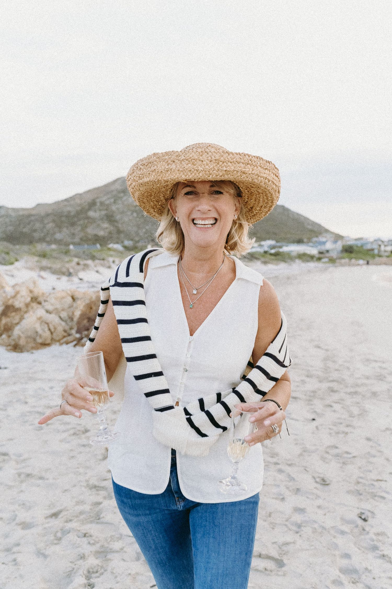 Mom having a ball on the beach with her summer hat & champagne