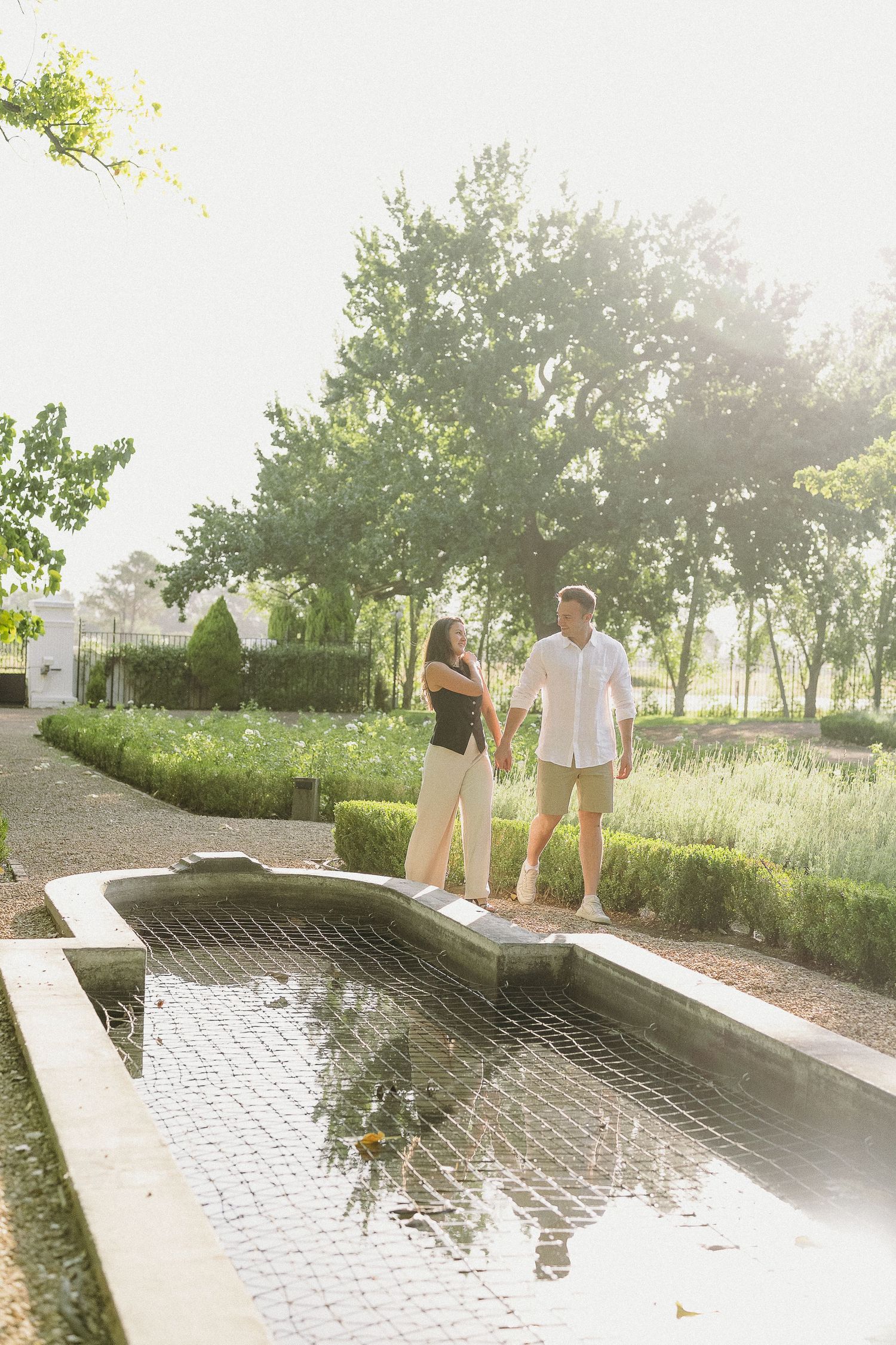 Newly engaged couple walking in the beautiful gardens at La Paris, Franschhoek.