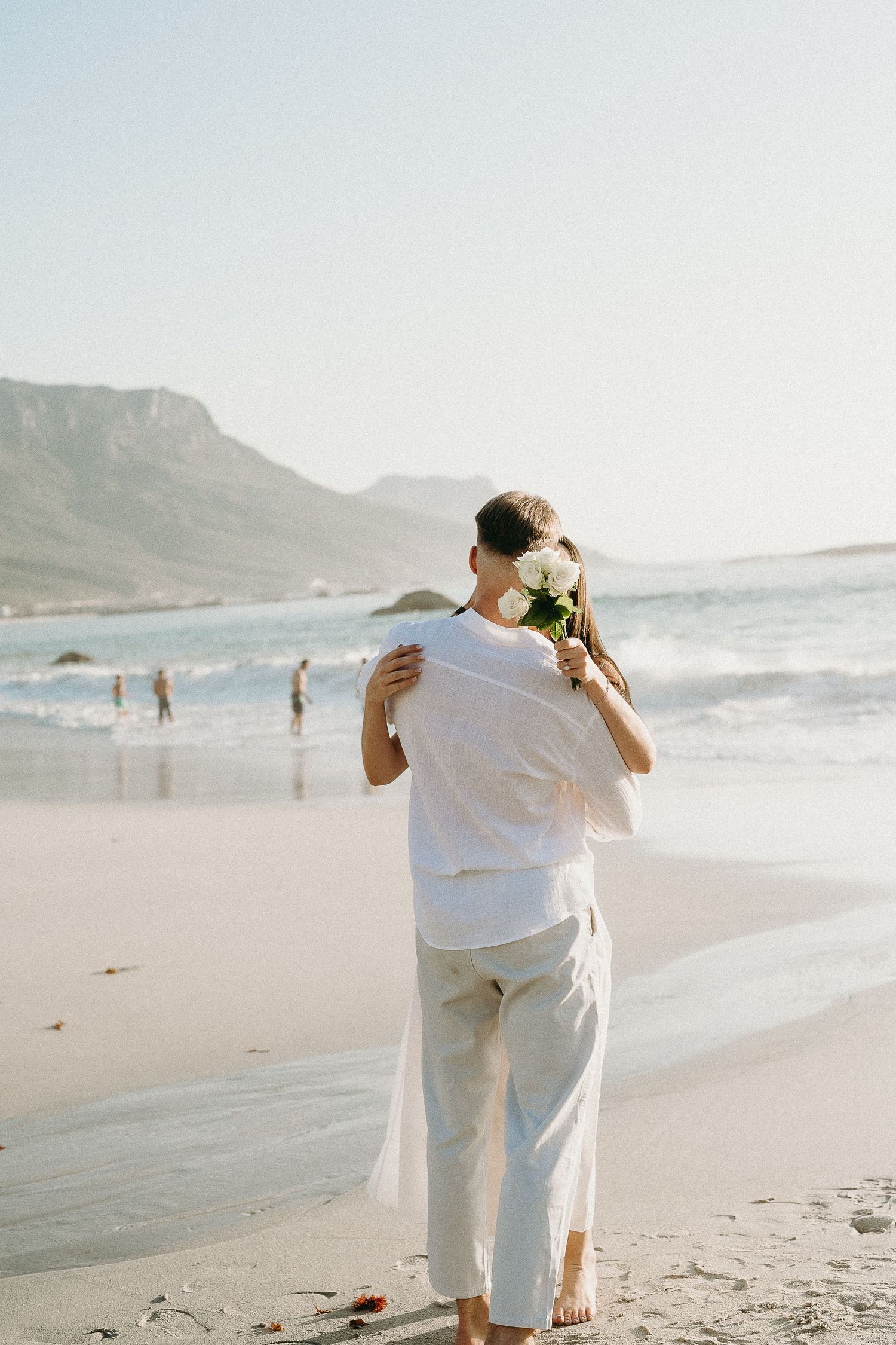 Kissing couple during golden hour at Camps Bay, Cape Town.