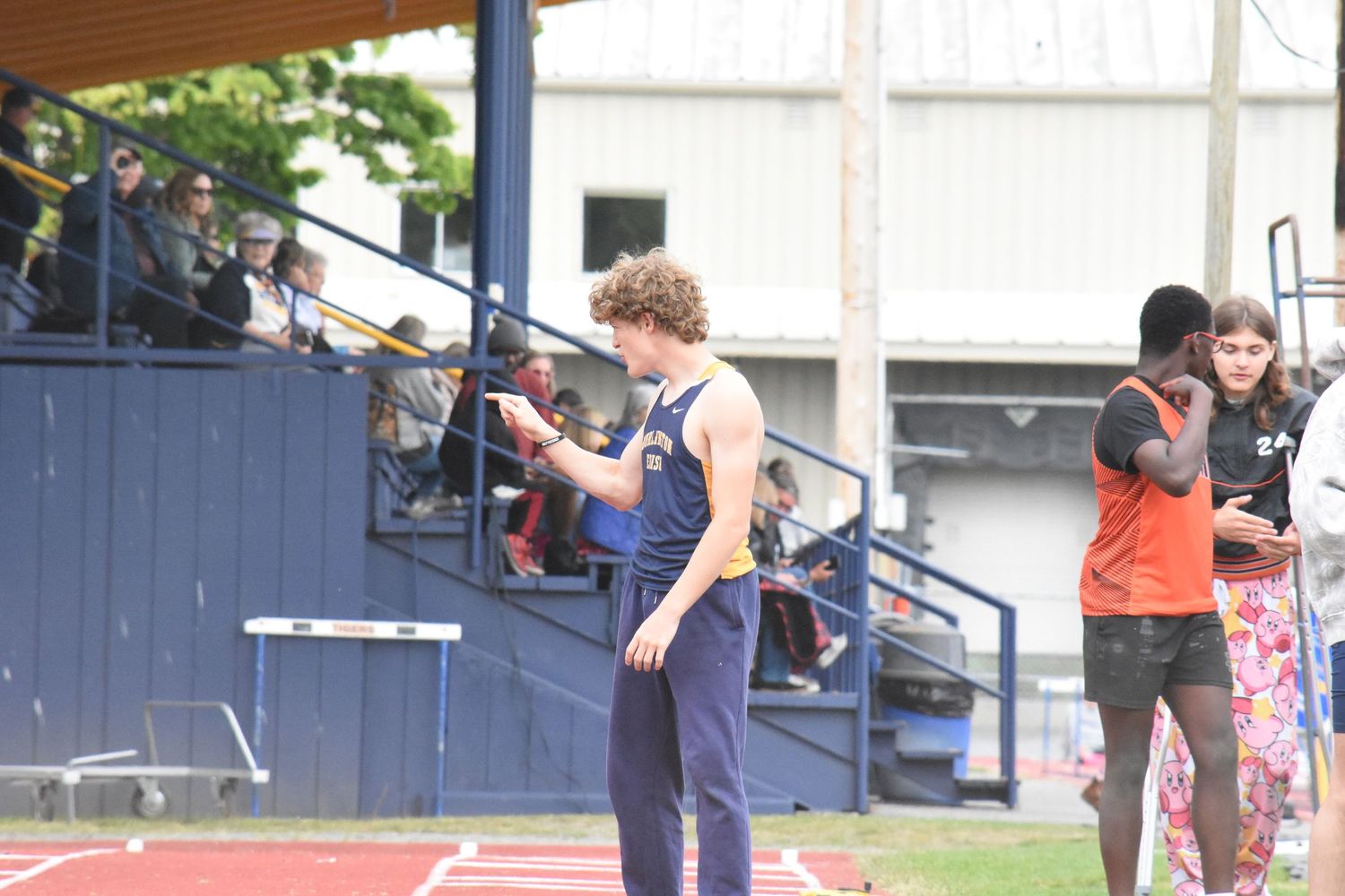 Athletes practice javelin throwing techniques at an outdoor track and field facility.