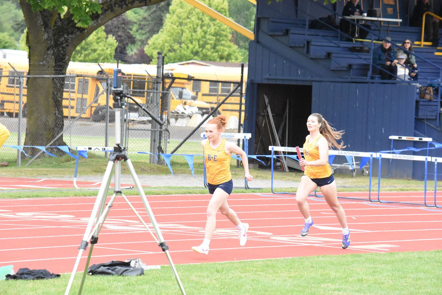 High school athletes practice pole vaulting on sunny afternoon at outdoor track and field facility.