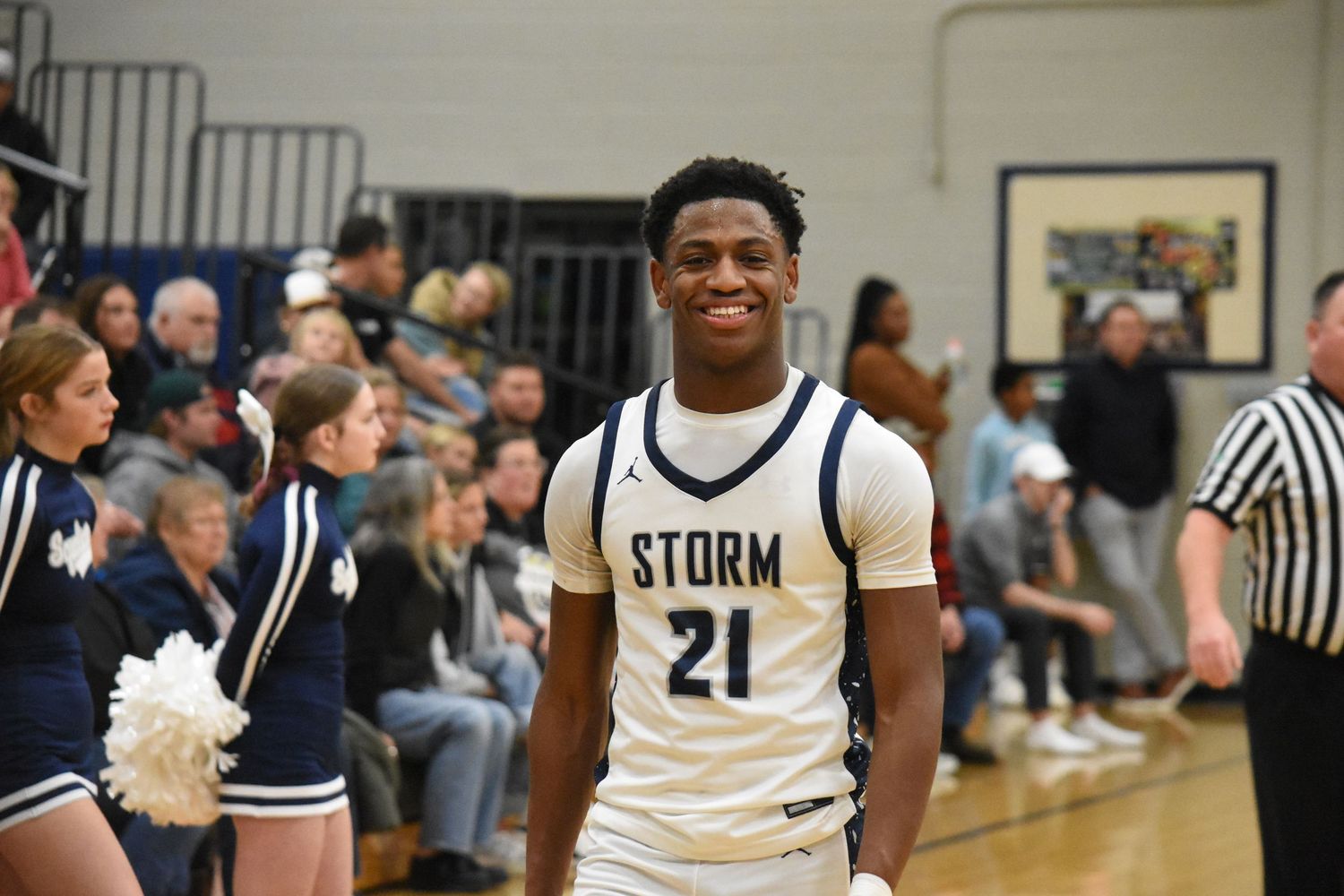 Player in white Storm jersey number 21 stands on basketball court during game.