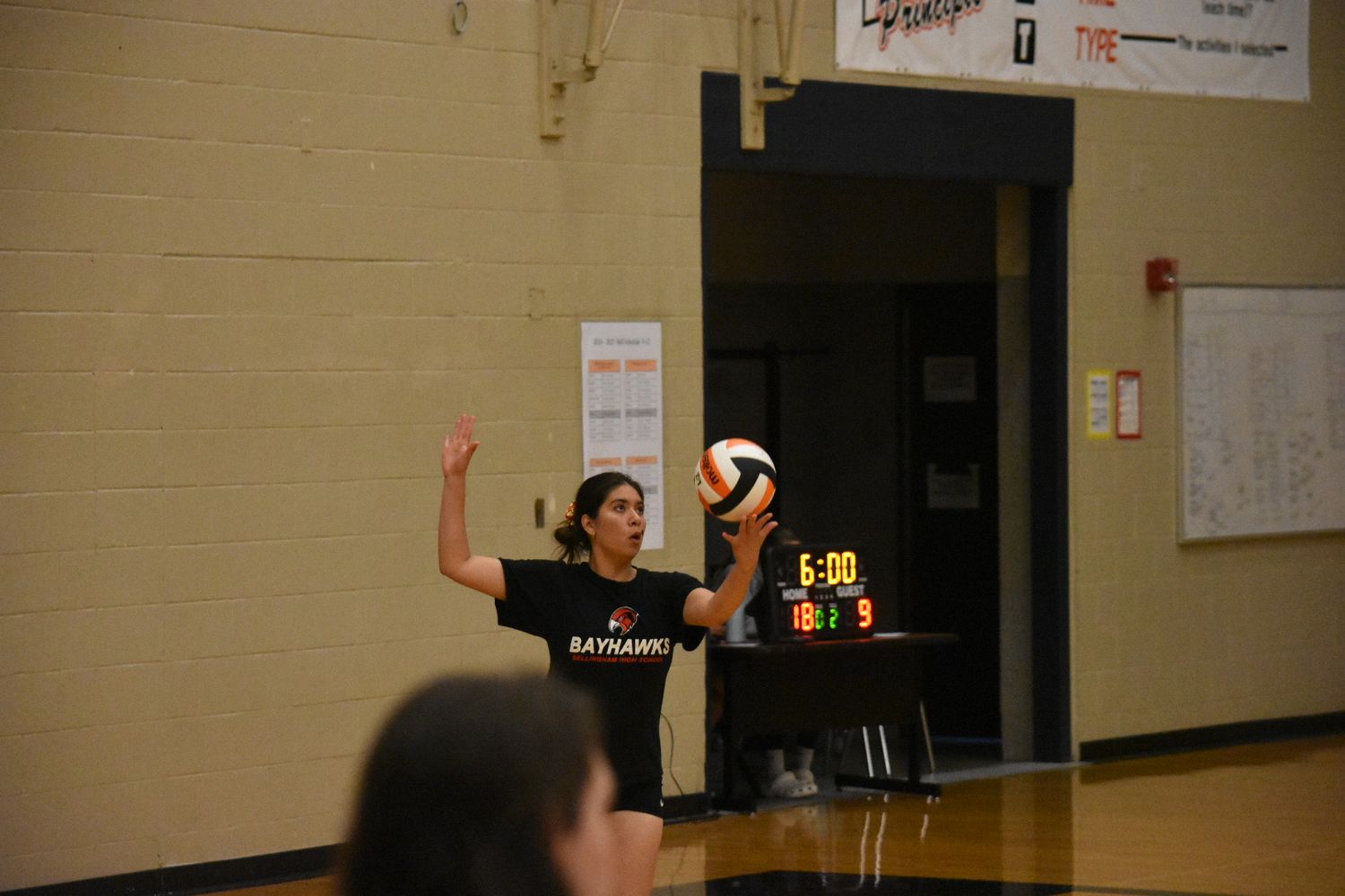 Athletes practicing volleyball serves and returns during team practice session.