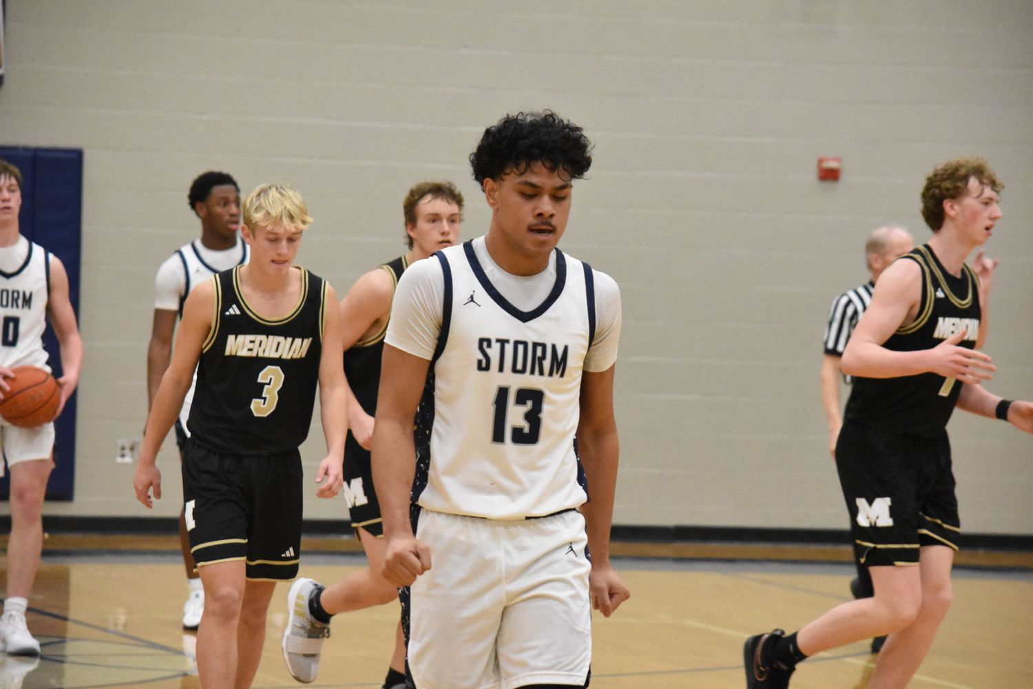 Players from Storm and opposing team move down court during basketball game.